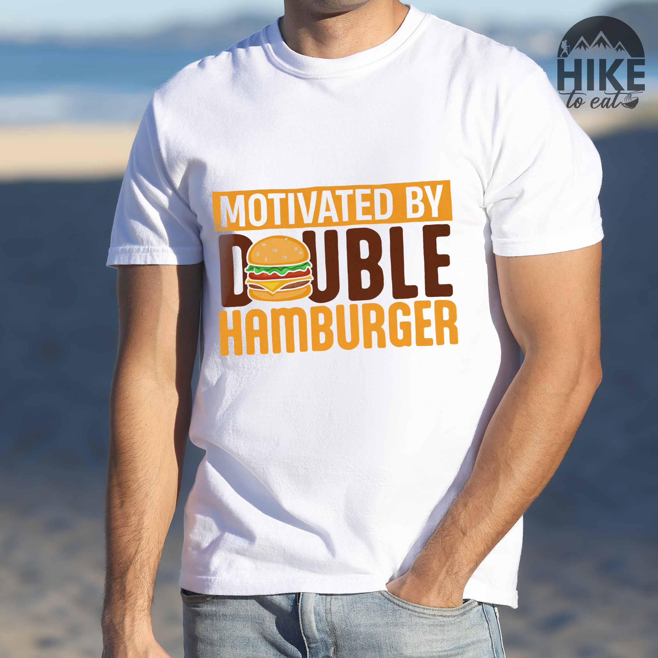 Man wearing white "Motivated by Double Hamburger" colored vintage tee with bold typography, illustrated juicy hamburger, and backpacker for burger enthusiasts.