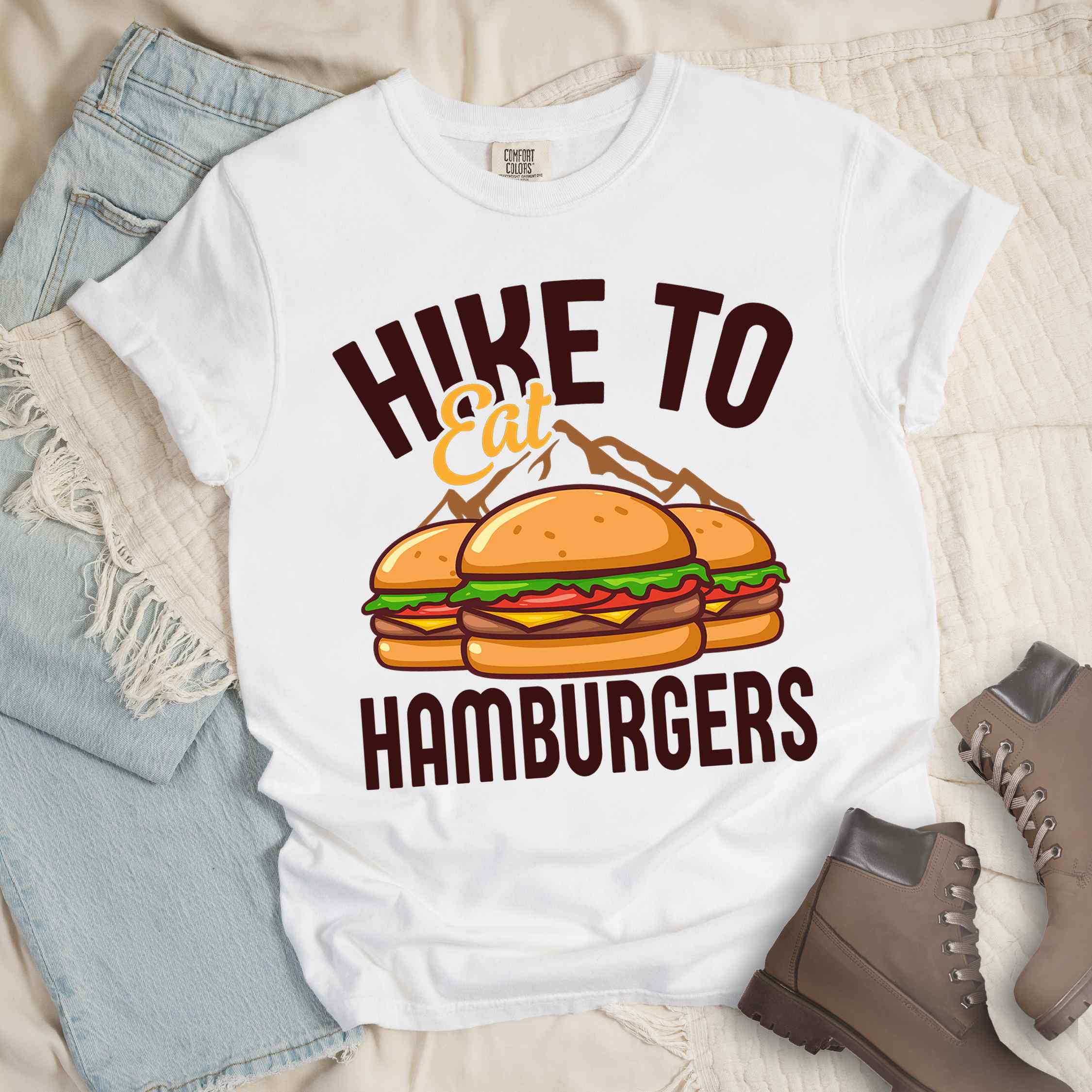White "Hike to Eat Hamburgers" colored vintage tee with bold typography, illustrated juicy hamburger, and backpacker for burger enthusiasts.