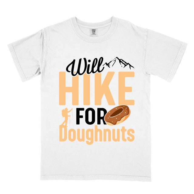 White Will Hike for Doughnuts statement t-shirt featuring chocolate doughnut graphic, mountain peaks, and hiker silhouette for doughnut lovers and outdoor enthusiasts on Comfort Colors 1717