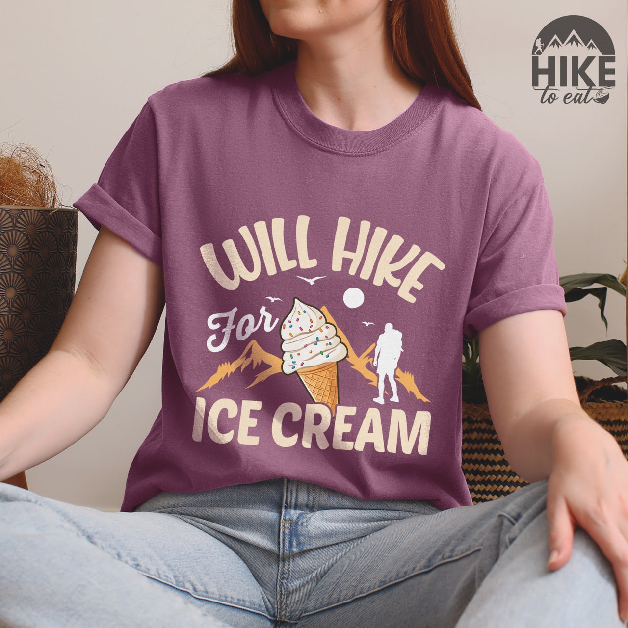 Berry (purple) Will Hike for Ice Cream statement tee with curved typography, script lettering, mountain peaks, hiker silhouette, and ice cream cone illustration on Comfort Colors shirt for dessert-loving outdoor enthusiasts