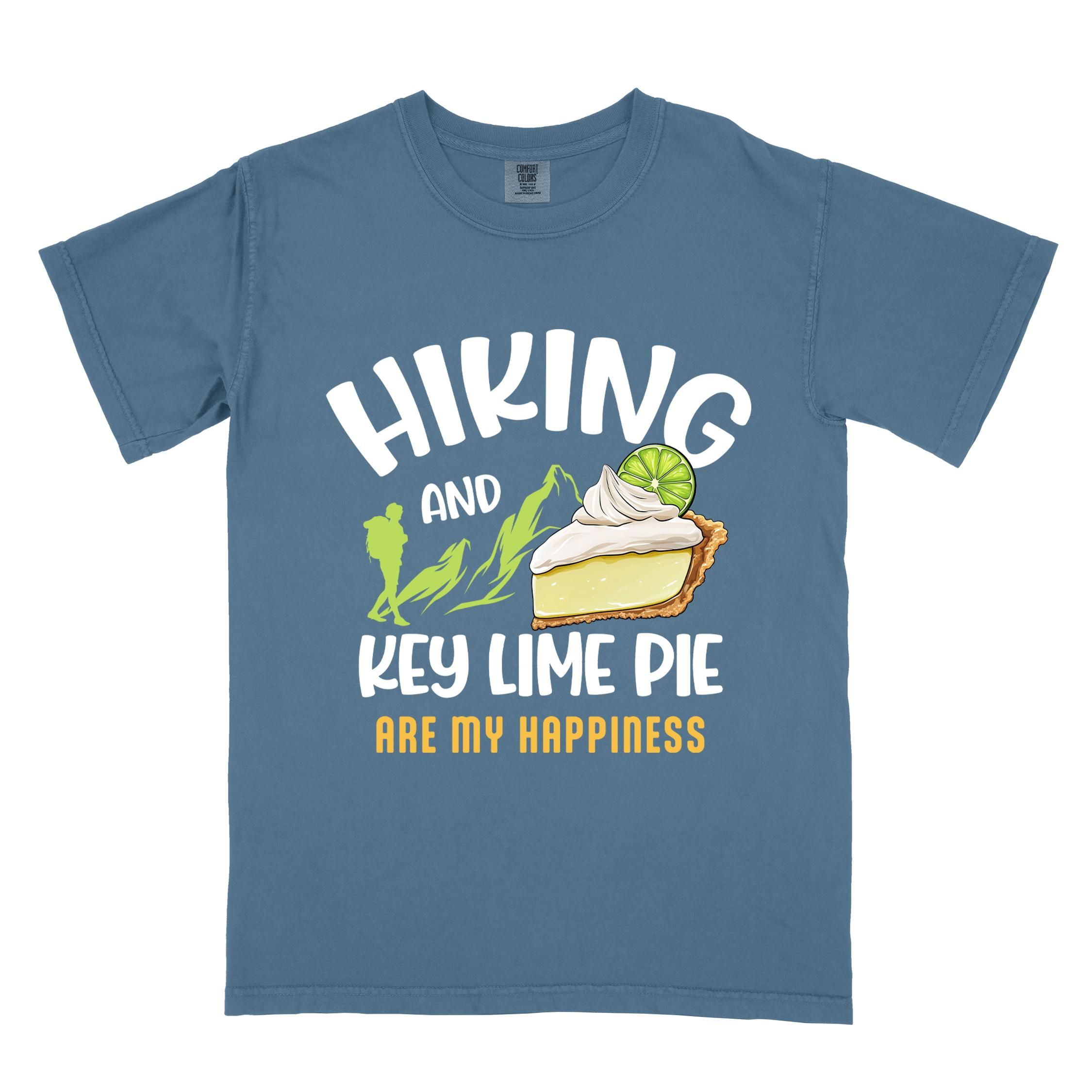 Blue jean "Hiking and key lime pie are my happiness" colored vintage tee with bold typography, mountains, birds, illustrated slice of key lime pie, and backpacker for pie lovers.