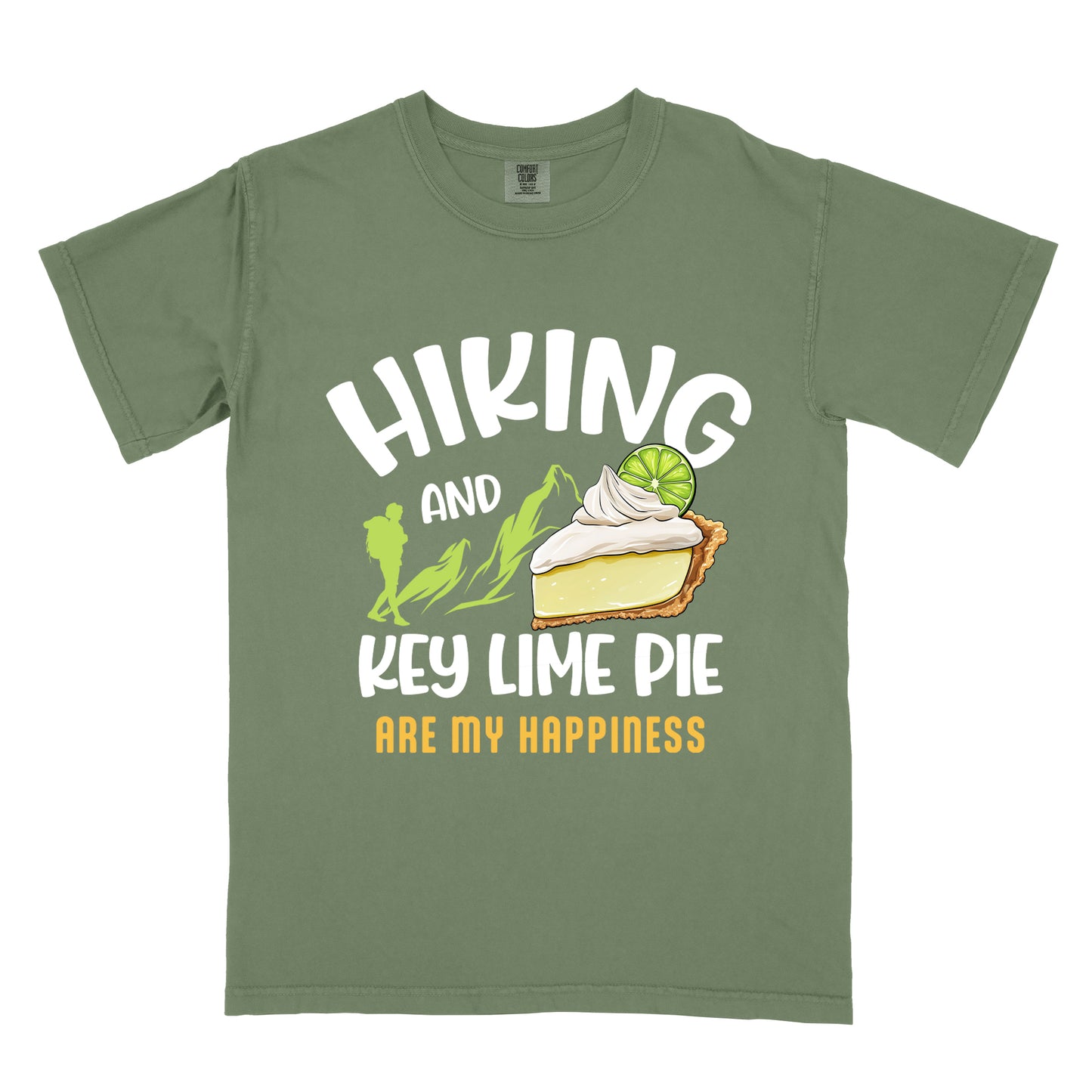 Moss (Dark Green) t-shirt with text "HIKING AND KEY LIME PIE ARE MY HAPPINESS". "HIKING" appears in white arched letters at the top, "AND" in small white text, "KEY LIME PIE" in large white text in the middle, and "ARE MY HAPPINESS" in gold/yellow at the bottom. The design includes green mountain silhouettes with a hiker silhouette and an illustration of a slice of key lime pie with whipped cream and lime garnish in between "AND" and "KEY LIME PIE." 