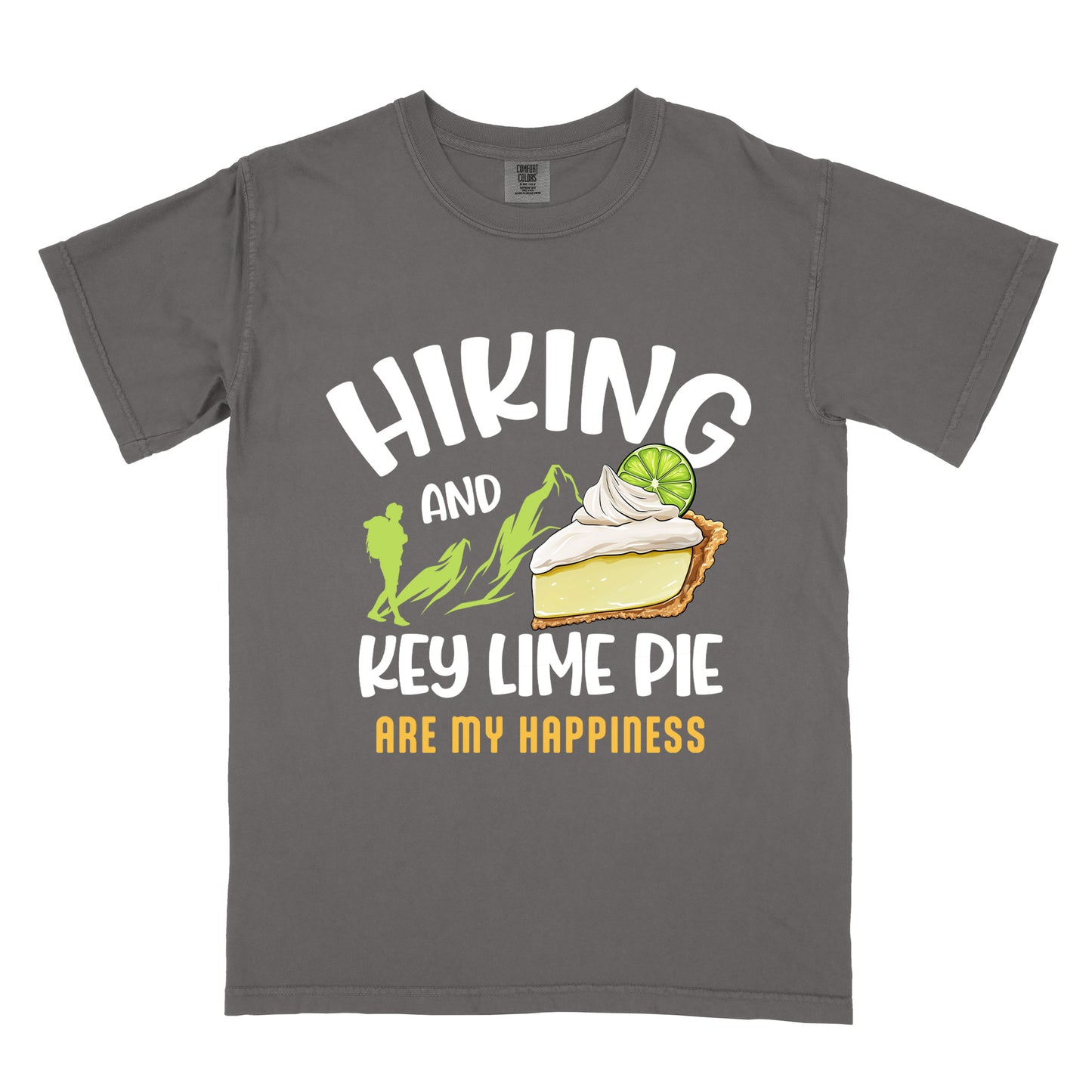 Pepper (Dark Gray) t-shirt with text "HIKING AND KEY LIME PIE ARE MY HAPPINESS". "HIKING" appears in white arched letters at the top, "AND" in small white text, "KEY LIME PIE" in large white text in the middle, and "ARE MY HAPPINESS" in gold/yellow at the bottom. The design includes green mountain silhouettes with a hiker silhouette and an illustration of a slice of key lime pie with whipped cream and lime garnish in between "AND" and "KEY LIME PIE." 