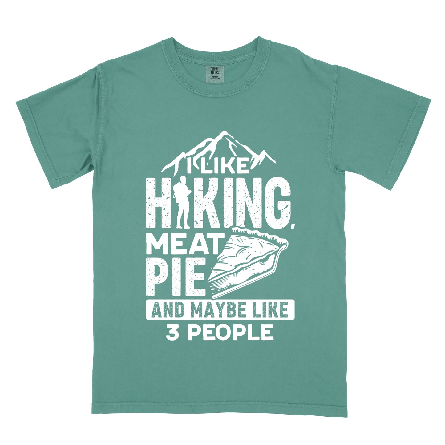 Light Green t-shirt with white distressed text reading "I LIKE HIKING, MEAT PIE AND MAYBE LIKE 3 PEOPLE". Mountain silhouettes appear above "I LIKE". The letter "I" in "HIKING" is replaced with a hiker silhouette. Next to "MEAT PIE" is an illustration of a slice of pie. All text and graphics are in white with a weathered, vintage appearance. The design combines outdoor activities, food preferences, and introvert humor.