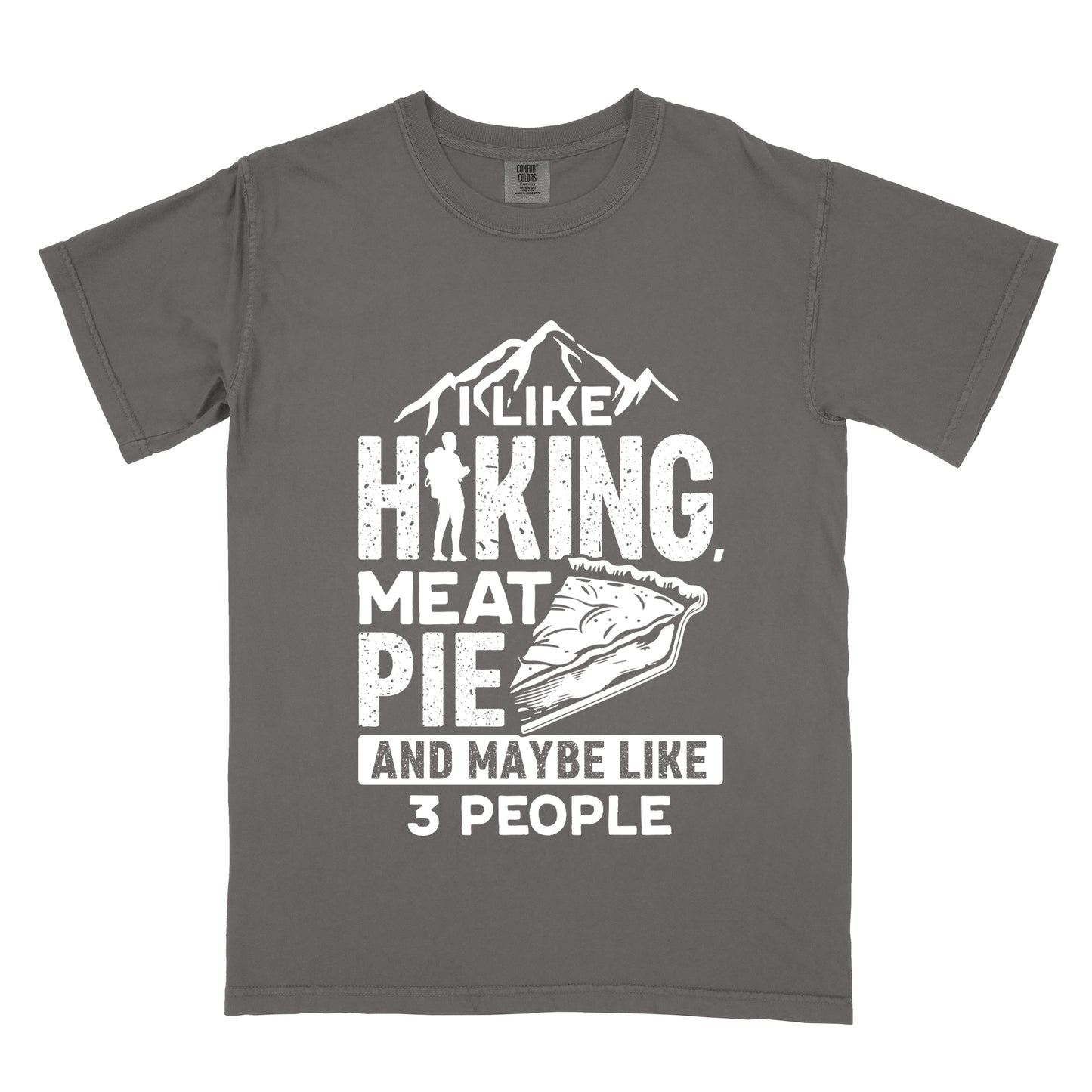 Pepper (Dark Gray) t-shirt with white distressed text reading "I LIKE HIKING, MEAT PIE AND MAYBE LIKE 3 PEOPLE". Mountain silhouettes appear above "I LIKE". The letter "I" in "HIKING" is replaced with a hiker silhouette. Next to "MEAT PIE" is an illustration of a slice of pie. All text and graphics are in white with a weathered, vintage appearance. The design combines outdoor activities, food preferences, and introvert humor.