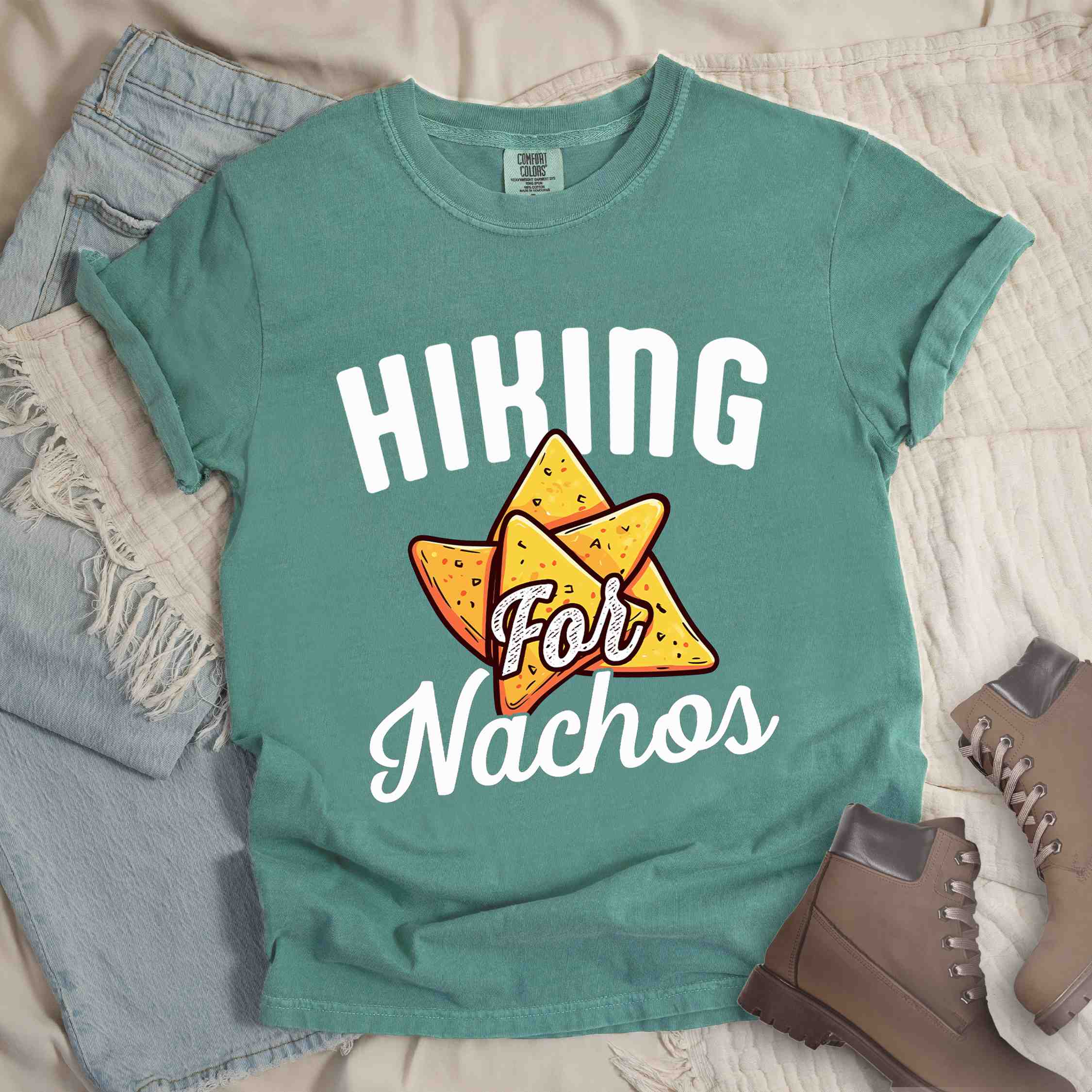 Light green "Hiking for Nachos" colored vintage tee with bold typography, illustrated crispy nachos chips, and backpacker craving for chips.