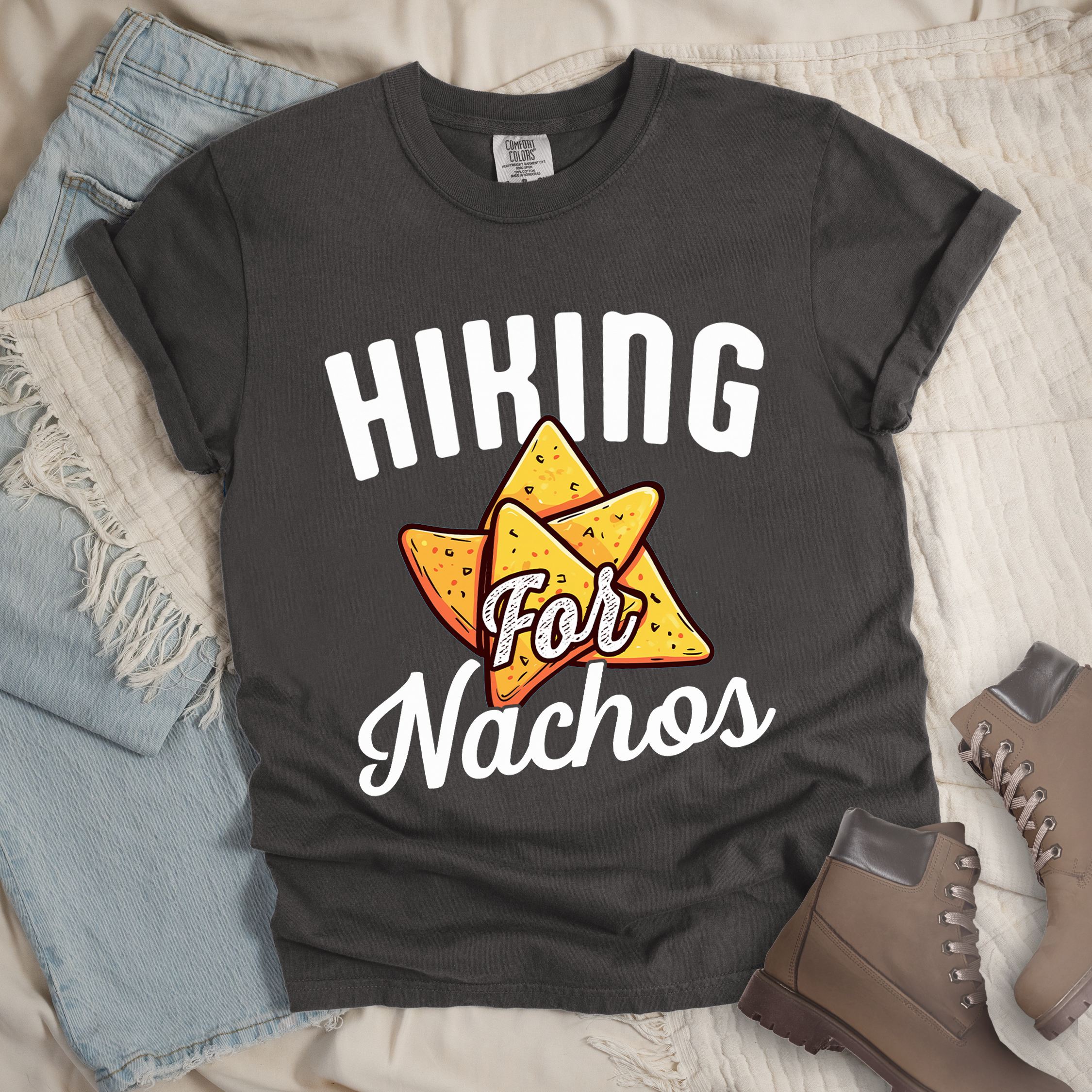 Dark grey shirt with Hiking Design featuring the phrase “Hiking for Nachos” and an illustration of golden nacho chips arranged in a triangle formation.