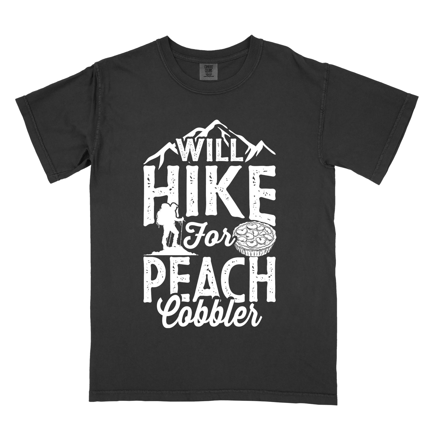 Black t-shirt with white text reading "WILL HIKE FOR PEACH COBBLER". "WILL HIKE" appears in large distressed letters at the top with mountain silhouettes, "For" in white script across the middle, and "PEACH COBBLER" in large distressed letters at the bottom. The design includes a small hiker figure with backpack on the left and an illustration of a peach cobbler pie. The design humorously connects hiking activity with dessert motivation.