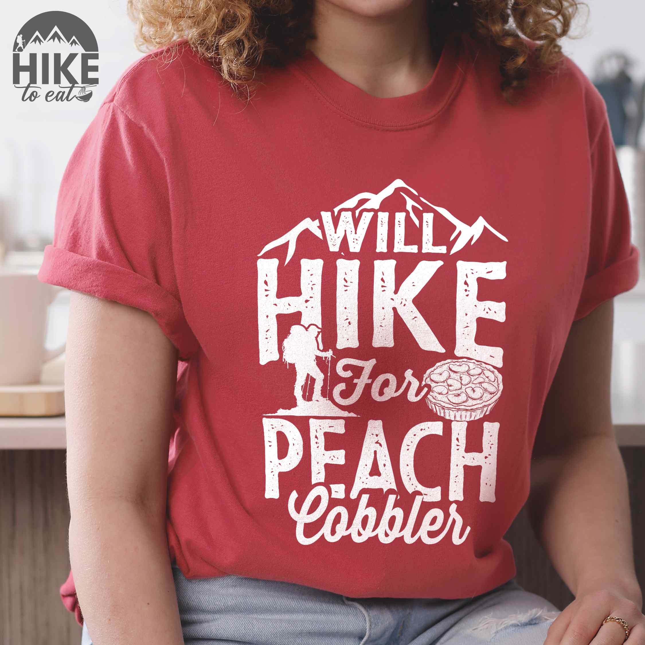 Crimson "Will hike for peach cobbler" colored vintage tee with bold typography, mountain, birds, illustrated peach cobbler, and backpacker looking for sweet treats.