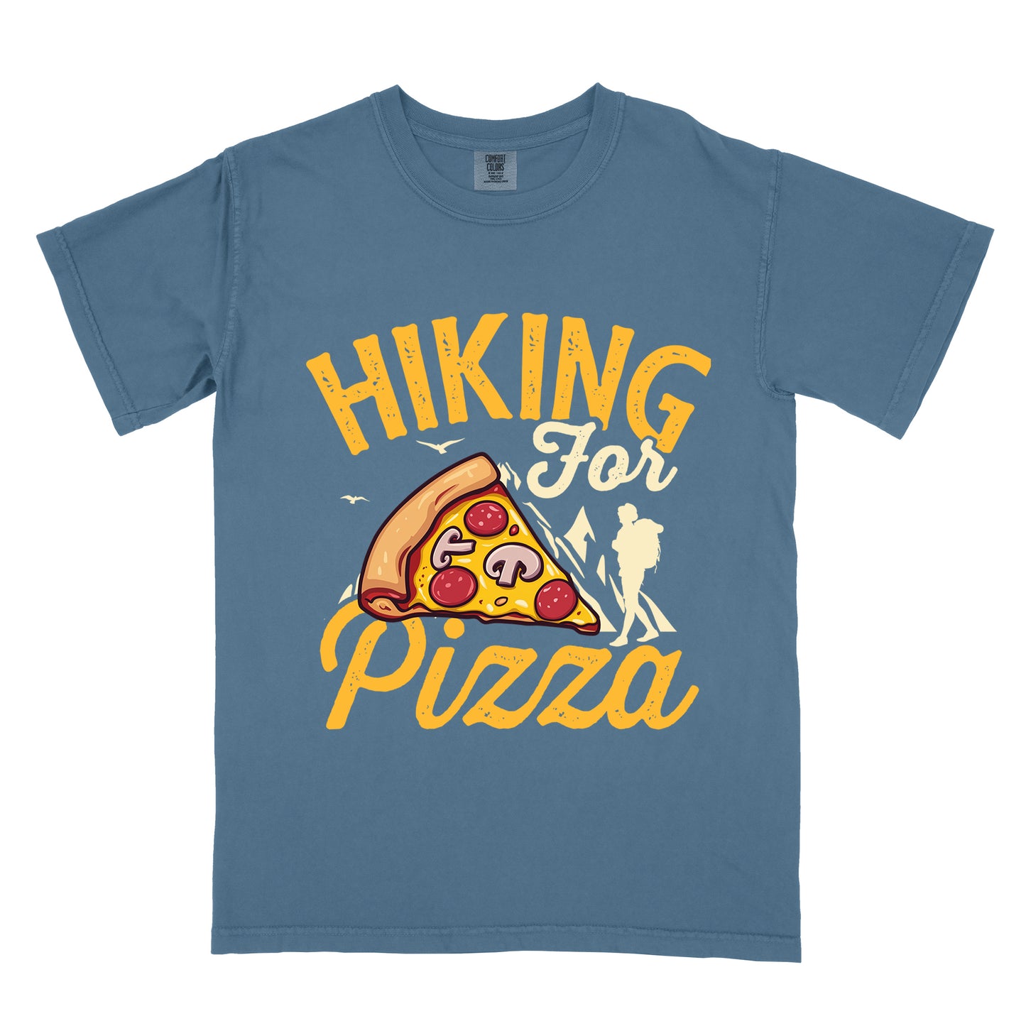 Blue Jean (Denim Blue) t-shirt with yellow distressed text reading "HIKING For Pizza". "HIKING" appears in large yellow letters at the top, "For" in cream script in the middle, and "Pizza" in yellow script at the bottom. Features a detailed pizza slice with pepperoni and mushrooms in the center and a cream silhouette of a hiker on the right side against mountain outlines. Small bird silhouettes appear near the mountains. The design connects hiking activity with food reward.