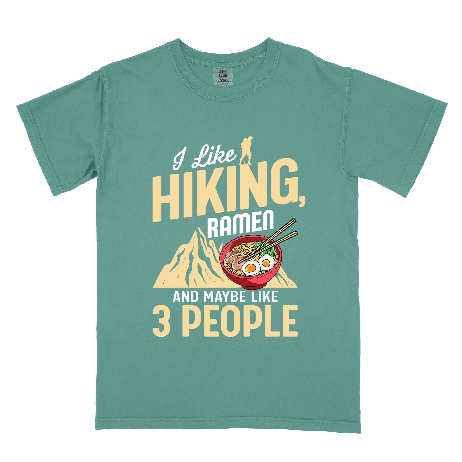 Light Green t-shirt with mixed text reading "I Like HIKING, RAMEN AND MAYBE LIKE 3 PEOPLE". "I Like" in white script at top with small gold hiker silhouette, "HIKING," in large gold letters, "RAMEN" in white, and "AND MAYBE LIKE 3 PEOPLE" in white and gold. Features a colorful illustration of a red ramen bowl with eggs, noodles and chopsticks, positioned above a gold mountain silhouette.