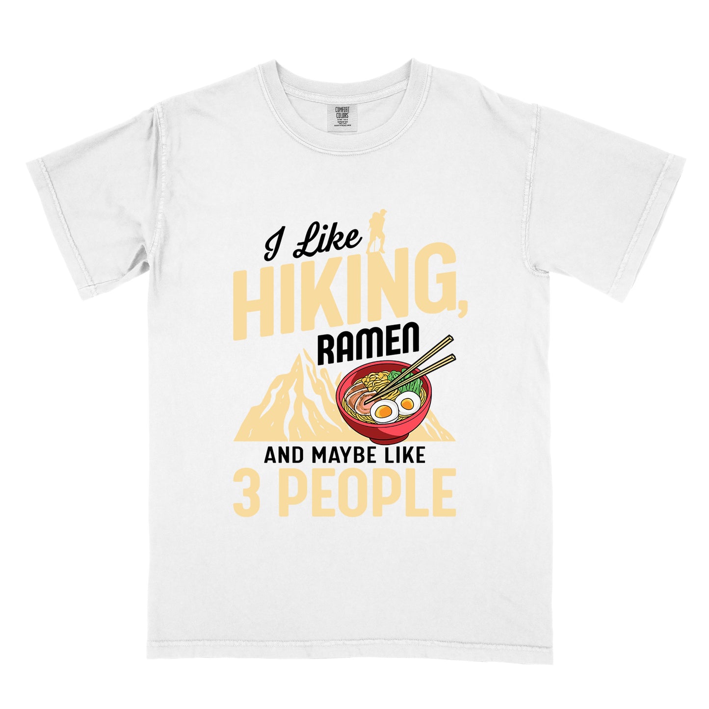 White t-shirt with mixed text reading "I Like HIKING, RAMEN AND MAYBE LIKE 3 PEOPLE". "I Like" in black script at top with small gold hiker silhouette, "HIKING," in large gold letters, "RAMEN" in black, and "AND MAYBE LIKE 3 PEOPLE" in black and gold. Features a colorful illustration of a red ramen bowl with eggs, noodles and chopsticks, positioned above a gold mountain silhouette.