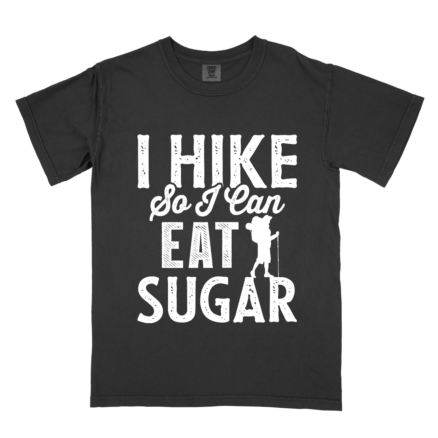 Black t-shirt with white distressed text reading "I HIKE So I Can EAT SUGAR". "I HIKE" appears in large block letters at the top, "So I Can" in script in the middle, and "EAT SUGAR" in block letters at the bottom. A small silhouette of a hiker with backpack and walking stick is positioned next to the word "EAT" and above "SUGAR".