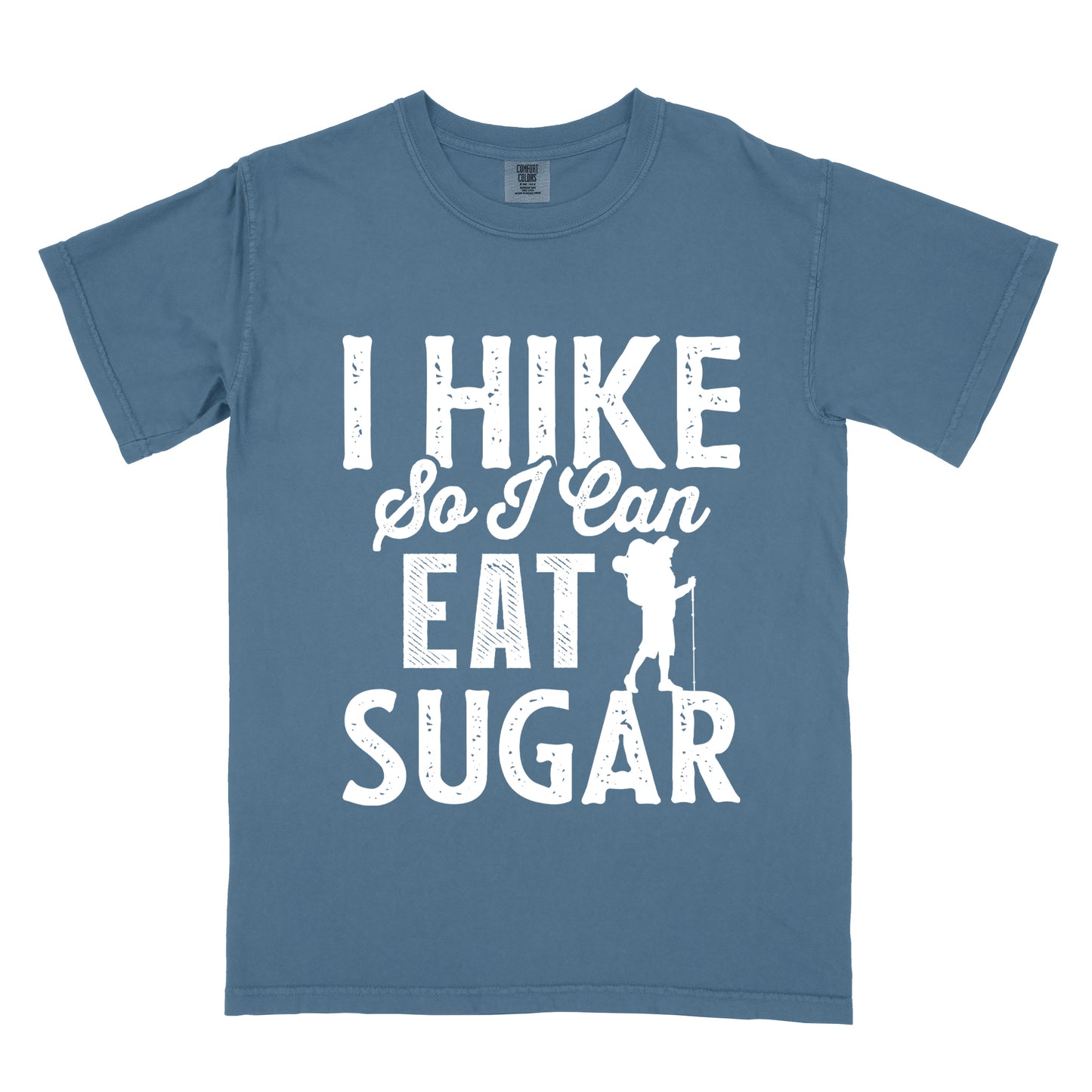 Blue Jean (Denim Blue) t-shirt with white distressed text reading "I HIKE So I Can EAT SUGAR". "I HIKE" appears in large block letters at the top, "So I Can" in script in the middle, and "EAT SUGAR" in block letters at the bottom. A small silhouette of a hiker with backpack and walking stick is positioned next to the word "EAT" and above "SUGAR".
