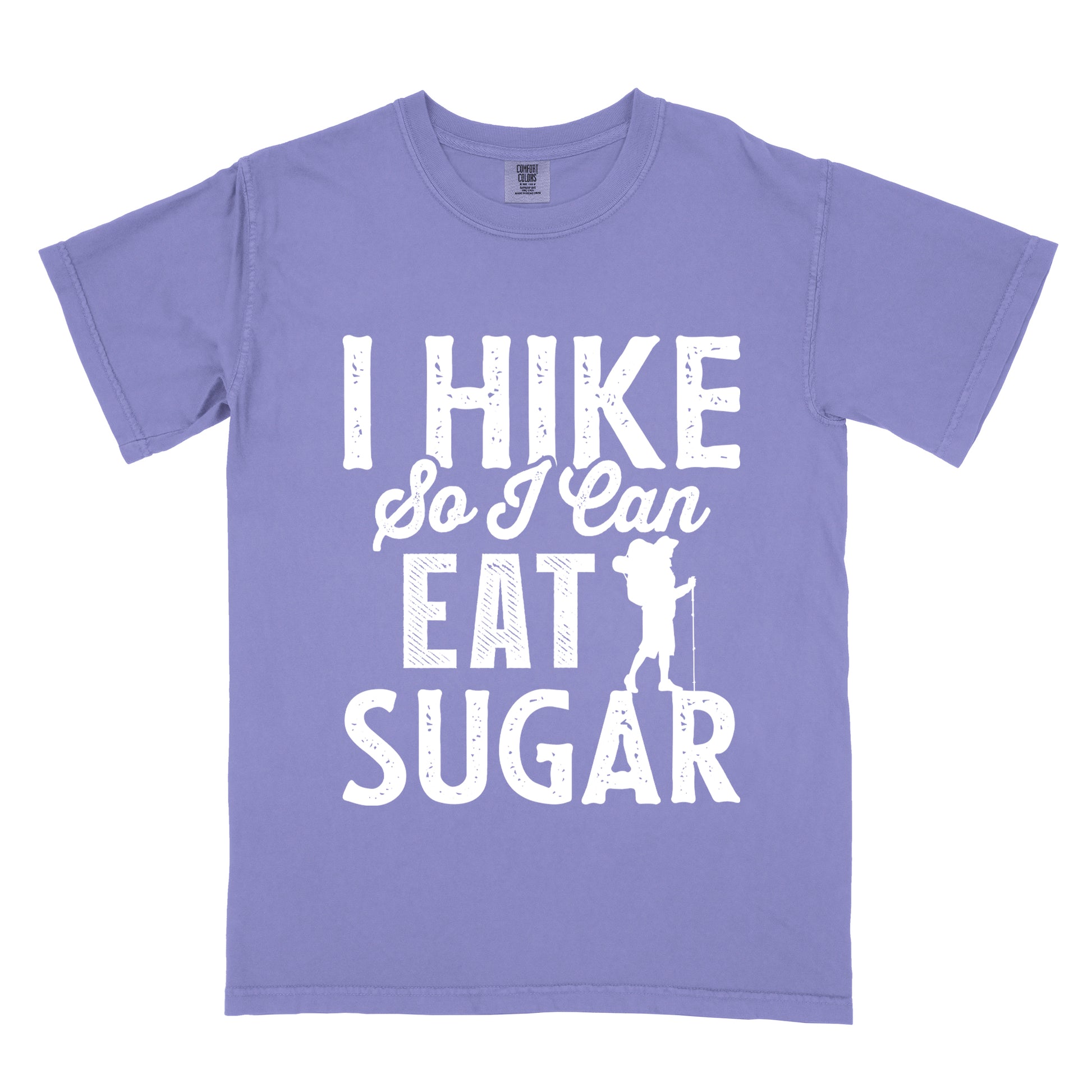 Violet t-shirt with white distressed text reading "I HIKE So I Can EAT SUGAR". "I HIKE" appears in large block letters at the top, "So I Can" in script in the middle, and "EAT SUGAR" in block letters at the bottom. A small silhouette of a hiker with backpack and walking stick is positioned next to the word "EAT" and above "SUGAR".