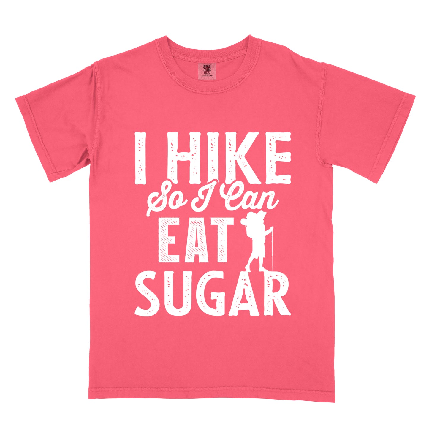 Watermelon (Light Coral) t-shirt with white distressed text reading "I HIKE So I Can EAT SUGAR". "I HIKE" appears in large block letters at the top, "So I Can" in script in the middle, and "EAT SUGAR" in block letters at the bottom. A small silhouette of a hiker with backpack and walking stick is positioned next to the word "EAT" and above "SUGAR".