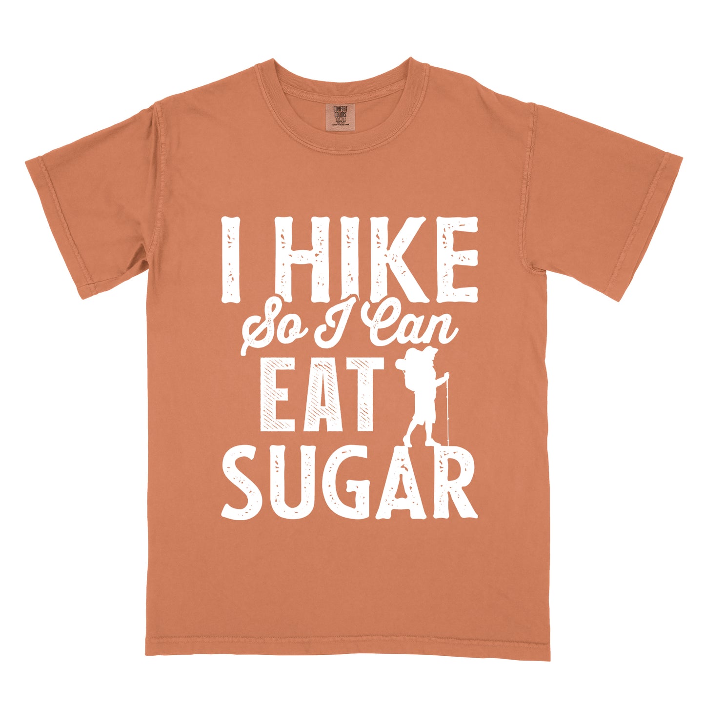 Yam (Brown) t-shirt with white distressed text reading "I HIKE So I Can EAT SUGAR". "I HIKE" appears in large block letters at the top, "So I Can" in script in the middle, and "EAT SUGAR" in block letters at the bottom. A small silhouette of a hiker with backpack and walking stick is positioned next to the word "EAT" and above "SUGAR".