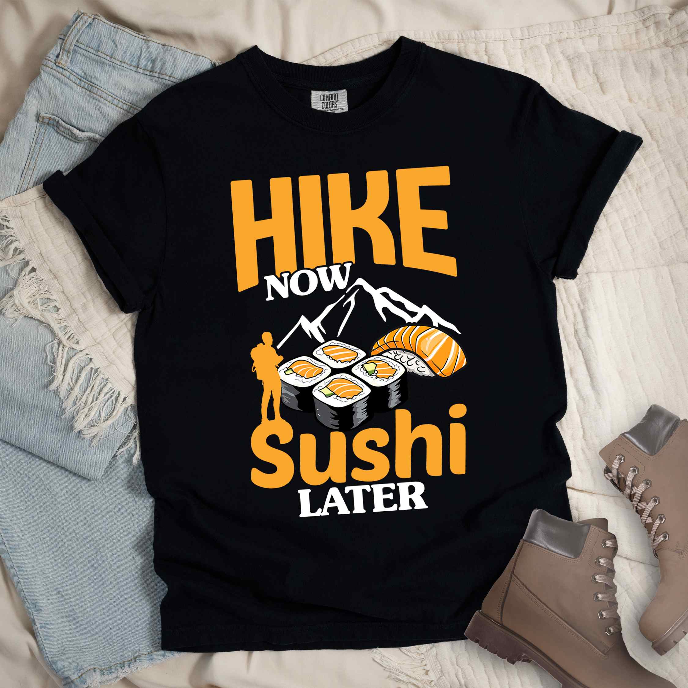 Black "Hike now sushi later" colored vintage tee with bold typography, birds, mountains, illustrated sushi platter, and backpacker for sushi lovers.