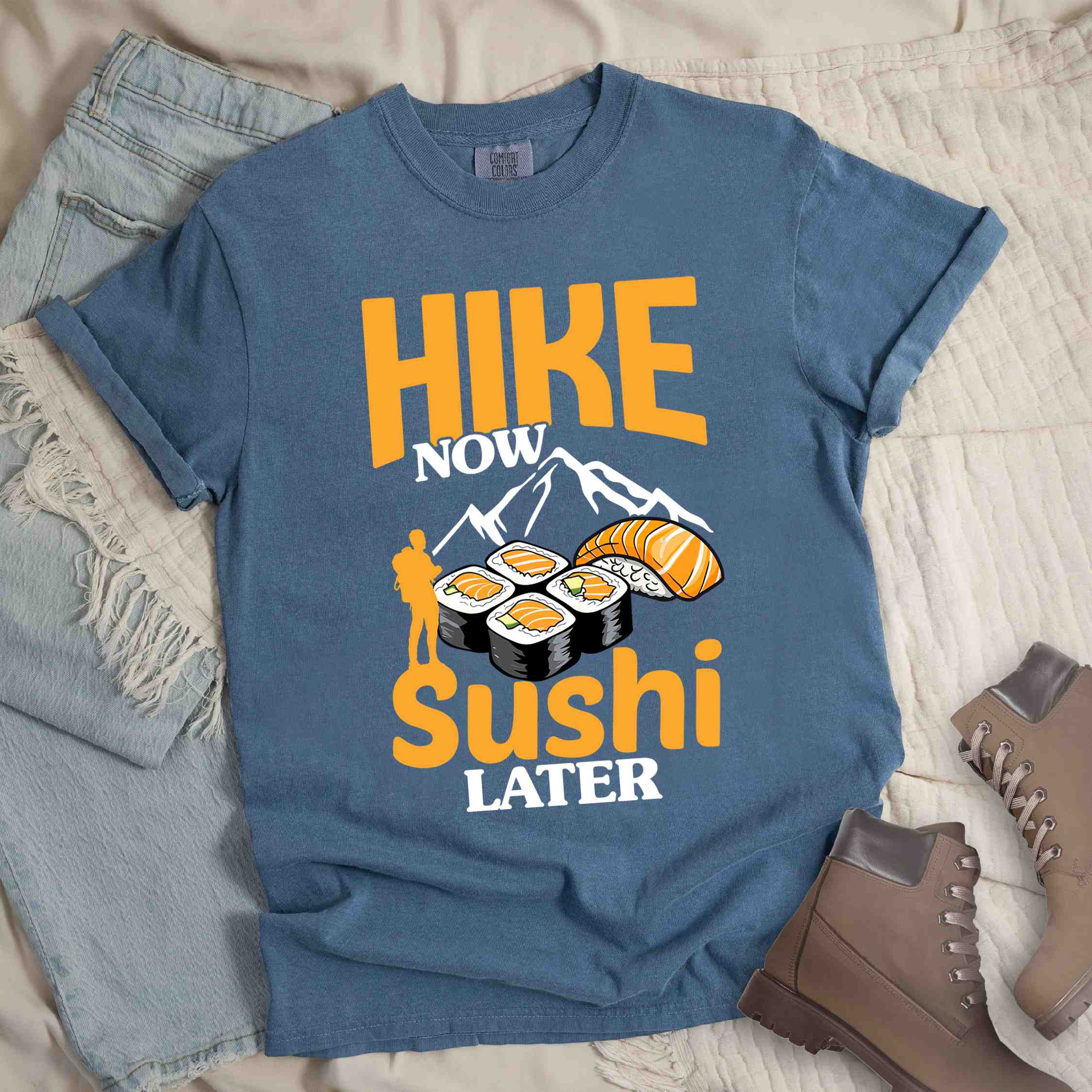 Blue jean "Hike now sushi later" colored vintage tee with bold typography, birds, mountains, illustrated sushi platter, and backpacker for sushi lovers.