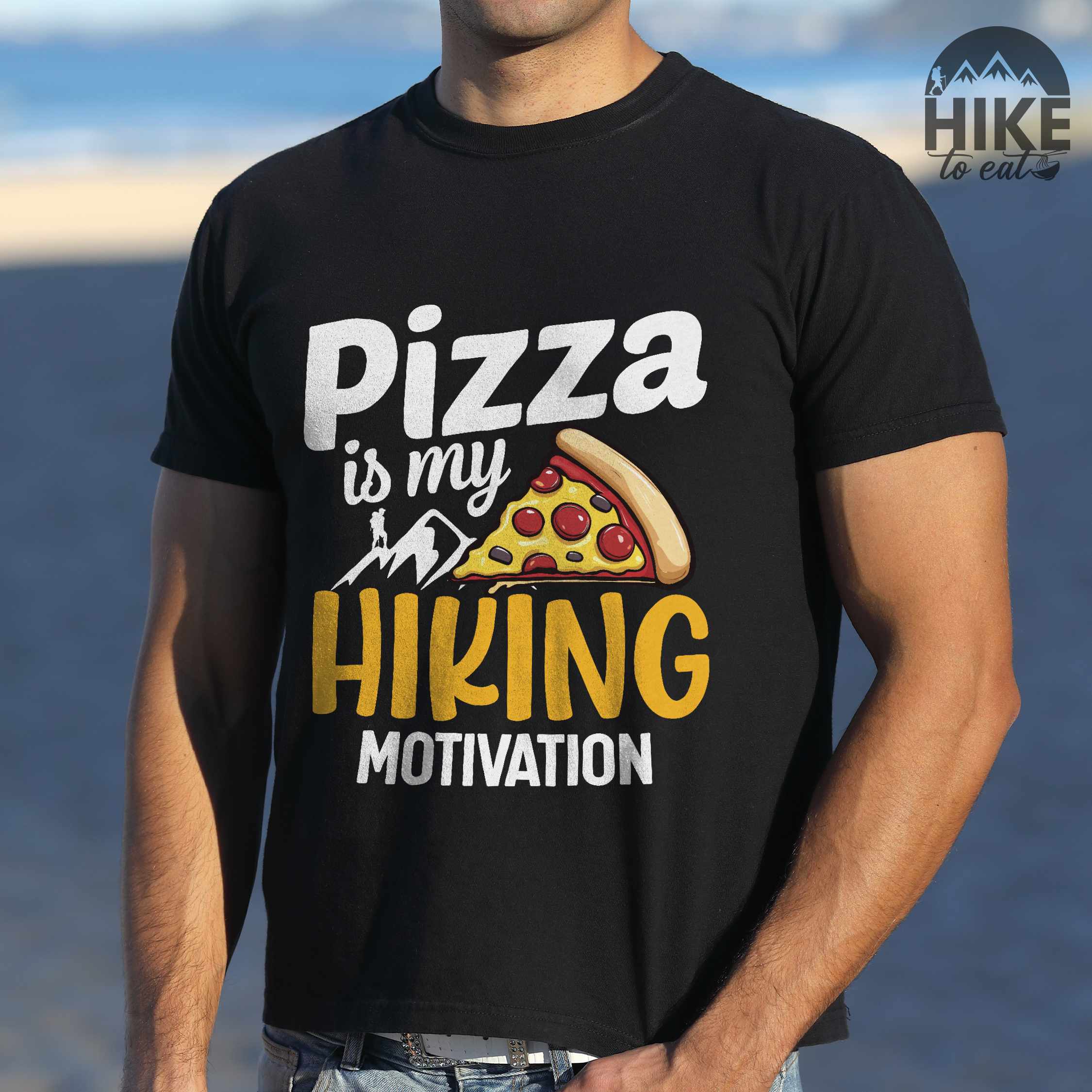 Man wearing black "Pizza is my hiking motivation" colored vintage tee with bold typography, birds, mountains, illustrated pizza slice, and backpacker for pizza lovers.