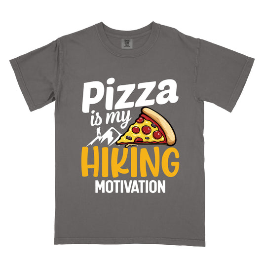 Pepper (Dark Gray) t-shirt with white and yellow text reading "Pizza is my HIKING MOTIVATION". "Pizza" appears in large white letters at the top, "is my" in smaller white script, "HIKING" in yellow at the bottom, and "MOTIVATION" in white. Features a colorful pizza slice with pepperoni toppings, white mountain silhouettes with a small hiker figure on a peak. The design humorously connects pizza as the incentive for hiking activities. 