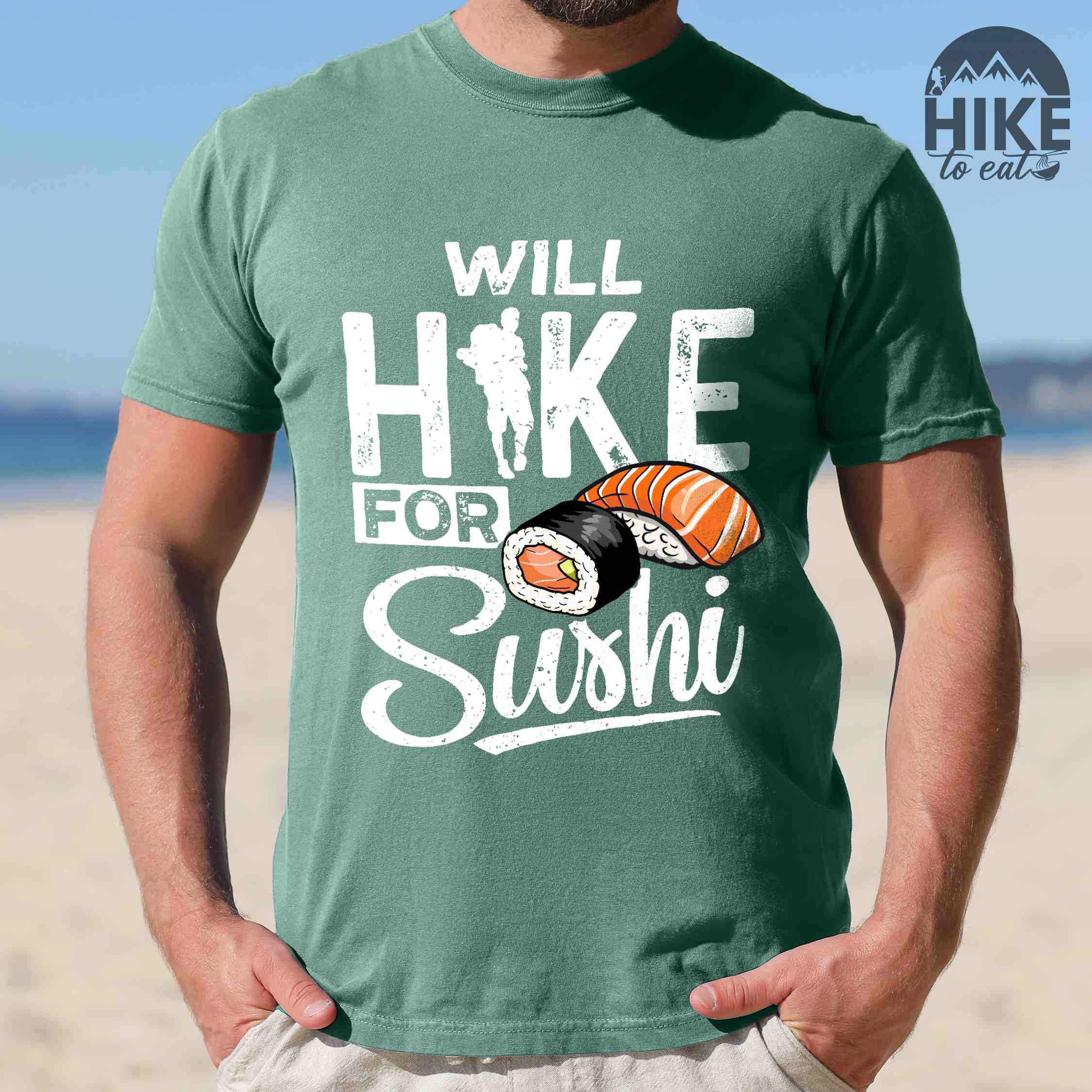 Man wearing light green "Will hike for sushi" colored vintage tee with bold typography, birds, mountains, illustrated sushi platter, and backpacker for sushi lovers.
