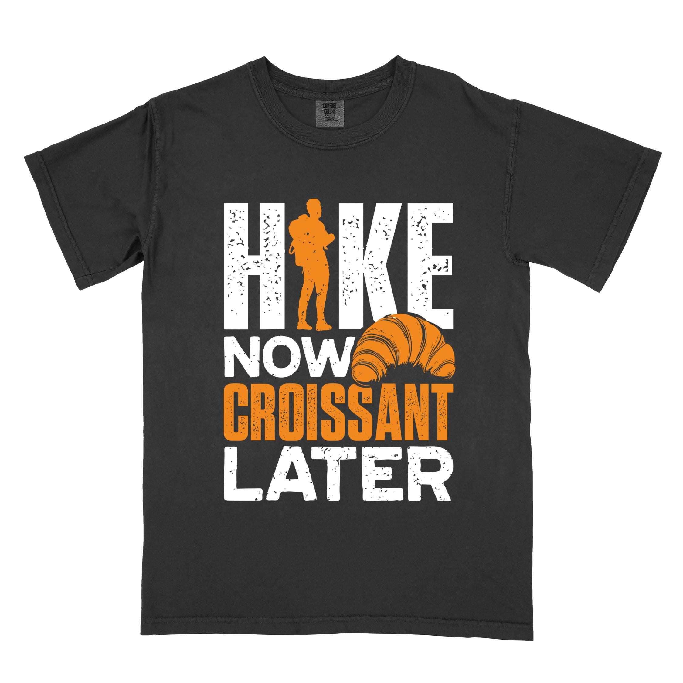 Black "Hike now croissant later" colored vintage tee with bold typography, birds, mountains, illustrated baked croissant, and backpacker for pastry enthusiasts.