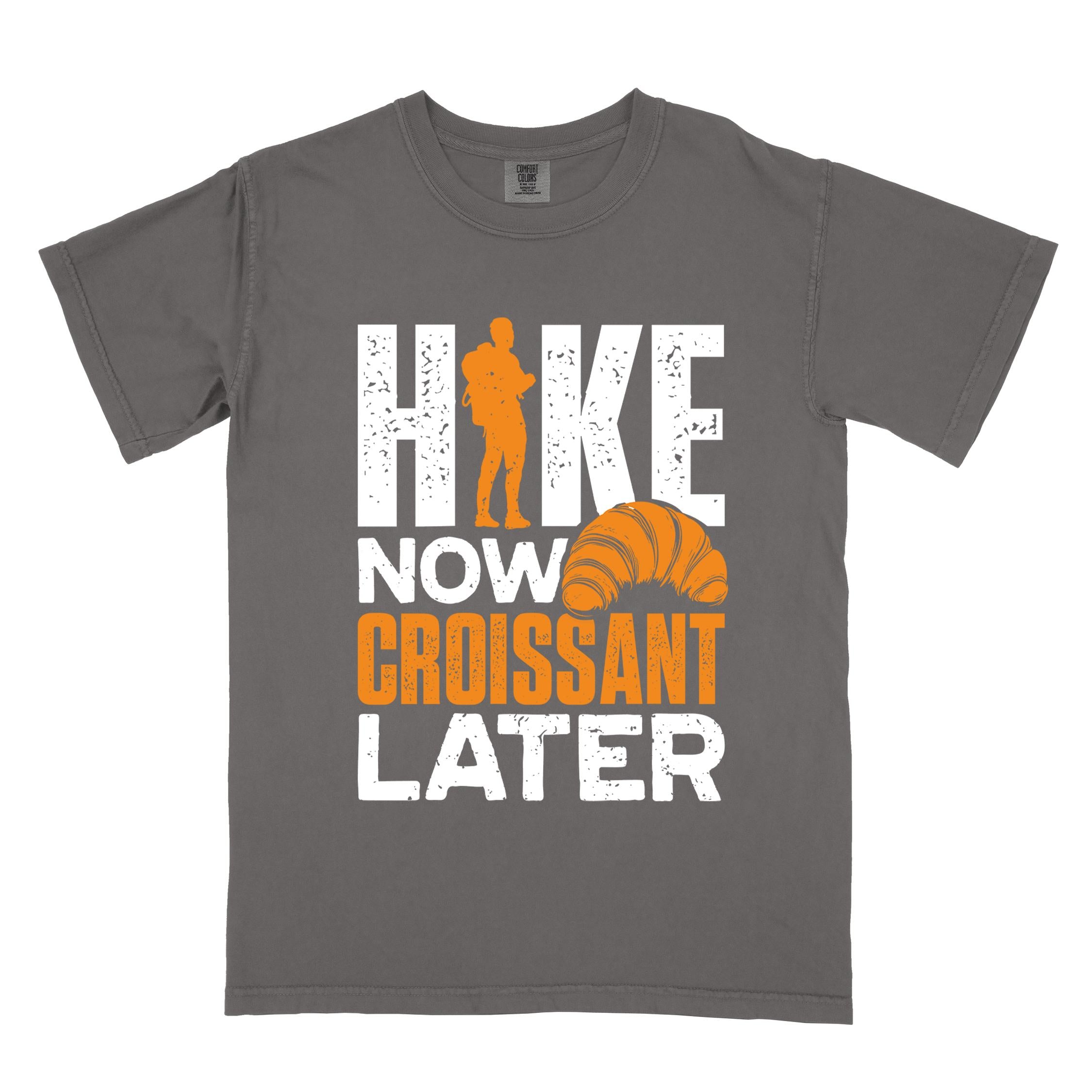 Pepper "Hike now croissant later" colored vintage tee with bold typography, birds, mountains, illustrated baked croissant, and backpacker for pastry enthusiasts.