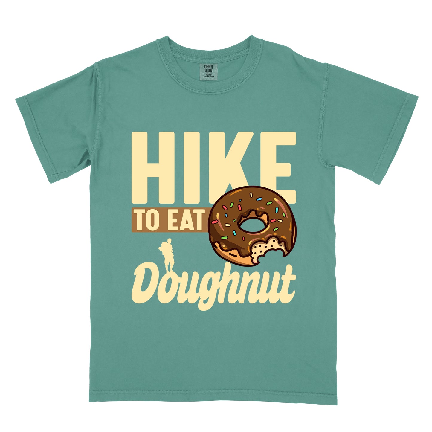 Light Green t-shirt with cream and tan text reading "HIKE TO EAT Doughnut". "HIKE" appears in large cream letters at the top, "TO EAT" on a tan rectangular background in the middle, and "Doughnut" in cream script at the bottom. Features a chocolate frosted doughnut with colorful sprinkles and a bite taken out of it on the right side, and a small cream silhouette of a hiker on the left. 