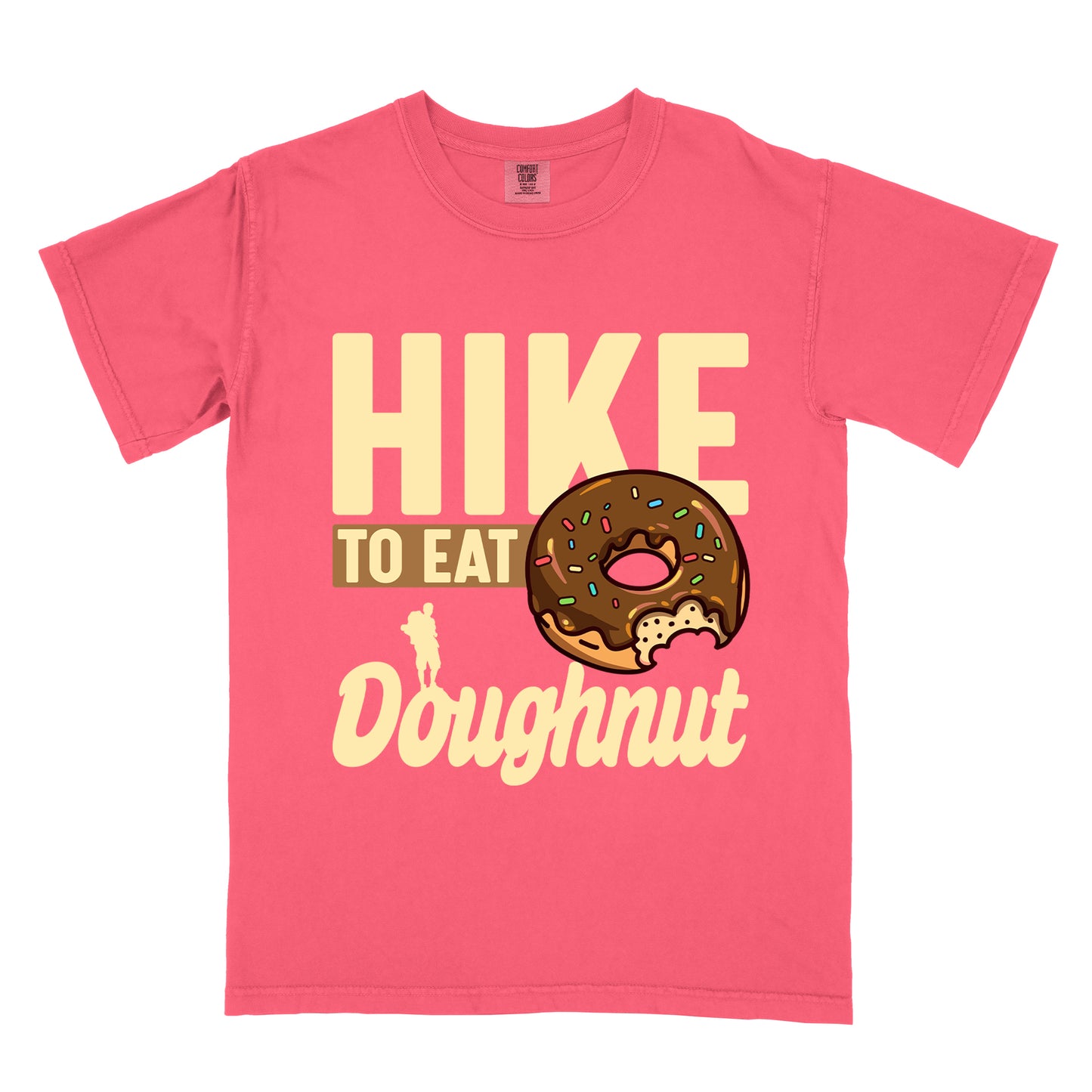 Watermelon (Light Coral) t-shirt with cream and tan text reading "HIKE TO EAT Doughnut". "HIKE" appears in large cream letters at the top, "TO EAT" on a tan rectangular background in the middle, and "Doughnut" in cream script at the bottom. Features a chocolate frosted doughnut with colorful sprinkles and a bite taken out of it on the right side, and a small cream silhouette of a hiker on the left. 