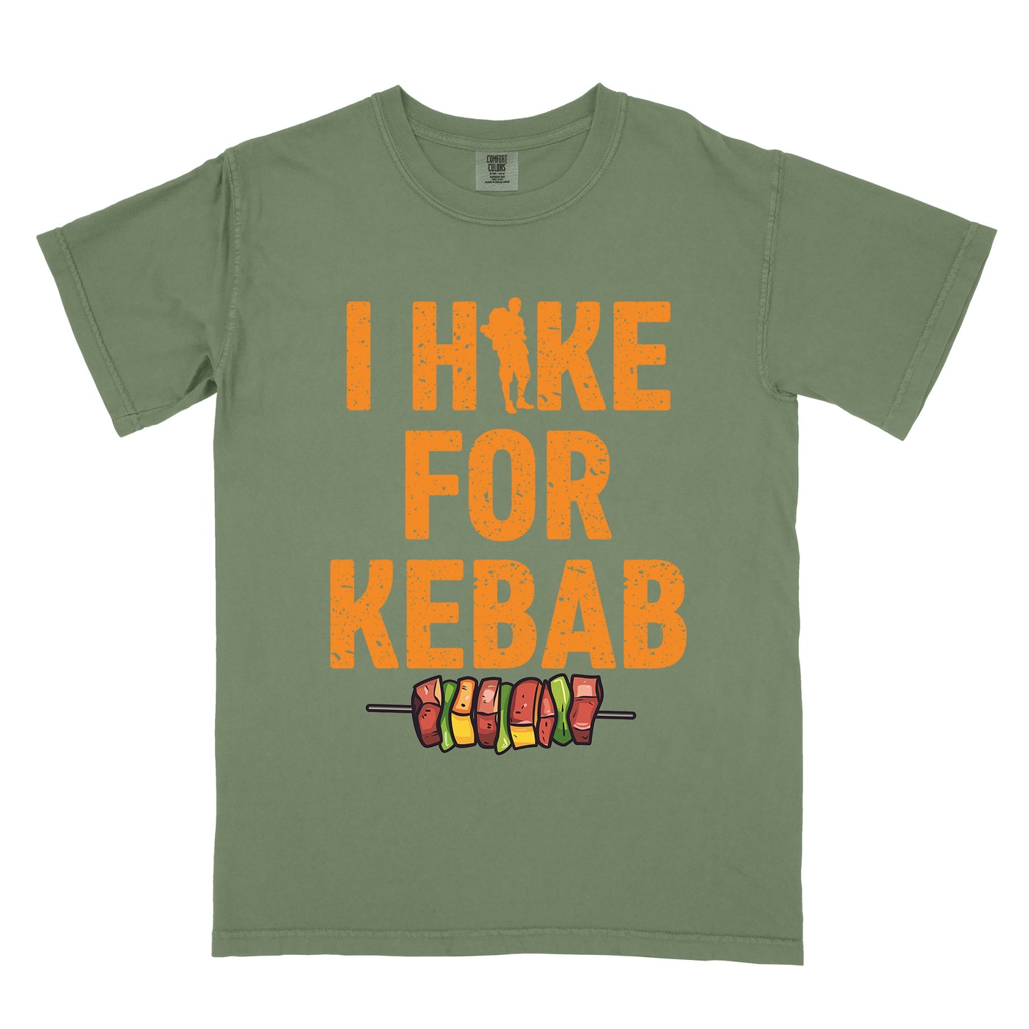 Moss (Dark Green) t-shirt with orange distressed text reading "I HIKE FOR KEBAB". "I HIKE" appears at the top with a hiker silhouette integrated into the letter "I", "FOR" in the middle, and "KEBAB" at the bottom. Below the text is a colorful illustration of a kebab skewer with meat and vegetables.
