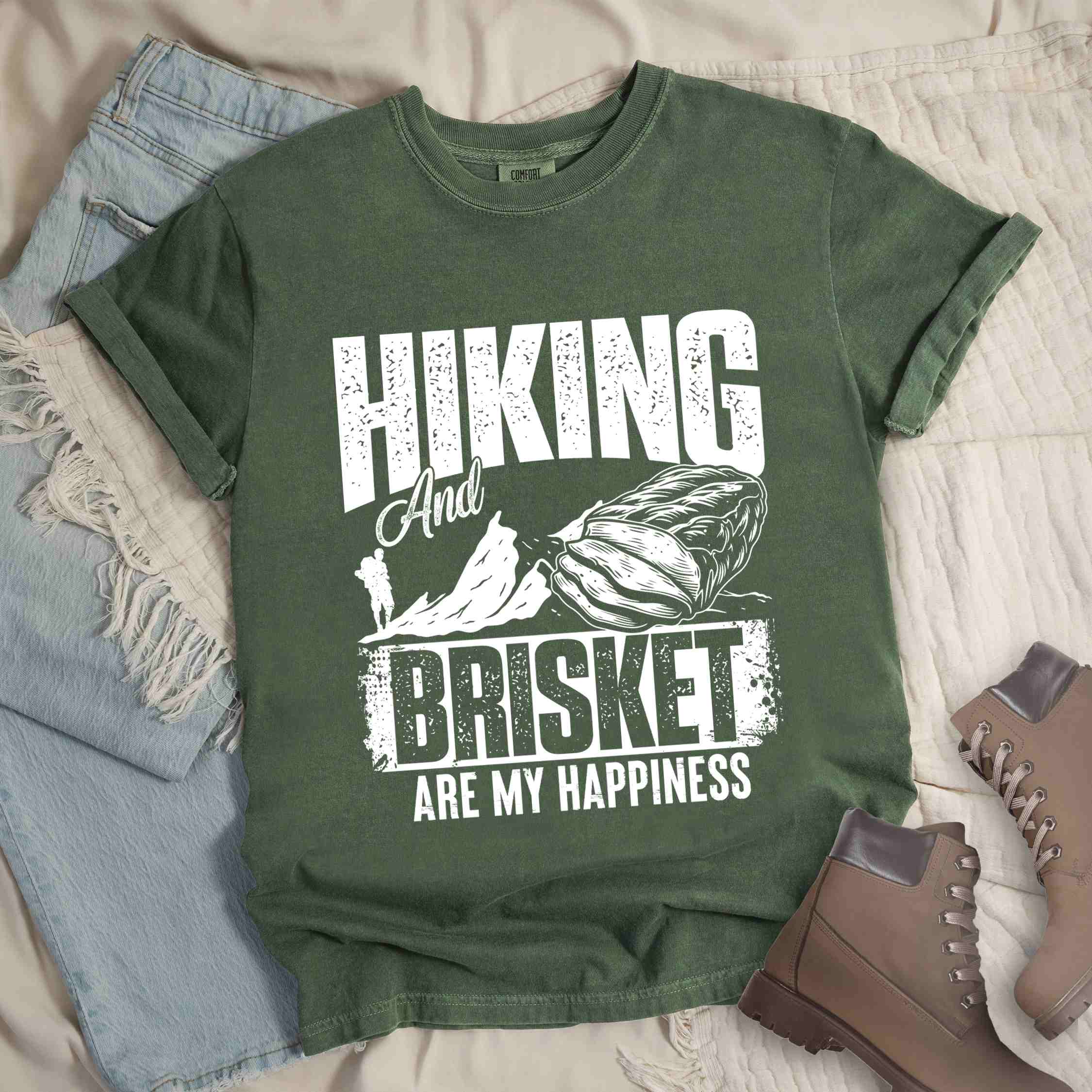 Moss "hiking and brisket are my happiness" colored vintage tee with bold typography, birds, mountains, illustrated bbq beef brisket, and backpacker for bbq lovers.