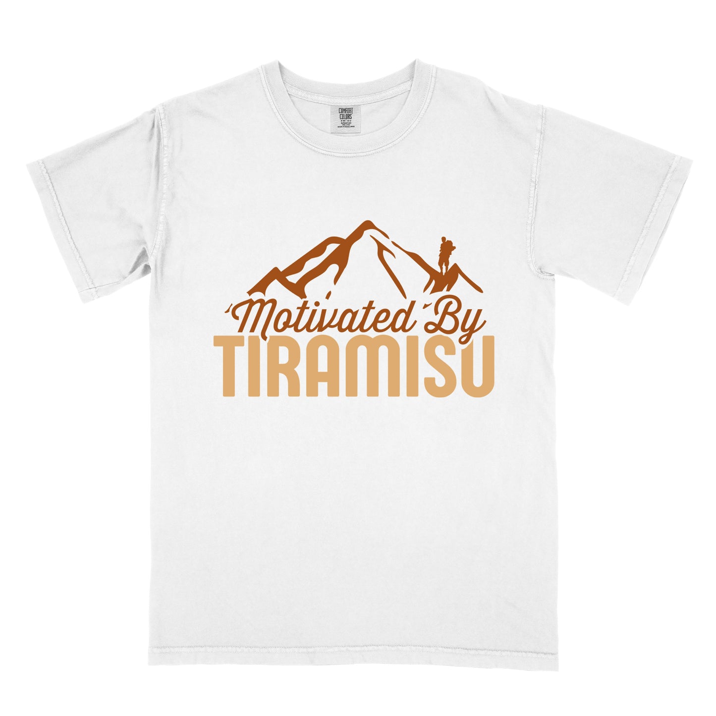 White t-shirt with brown and gold text reading "Motivated By TIRAMISU". "Motivated By" appears in brown script underneath a brown mountain silhouette with a small hiker figure on the peak, and "TIRAMISU" in large gold letters at the bottom. The design humorously connects the Italian coffee-flavored dessert as motivation for hiking and outdoor activities.