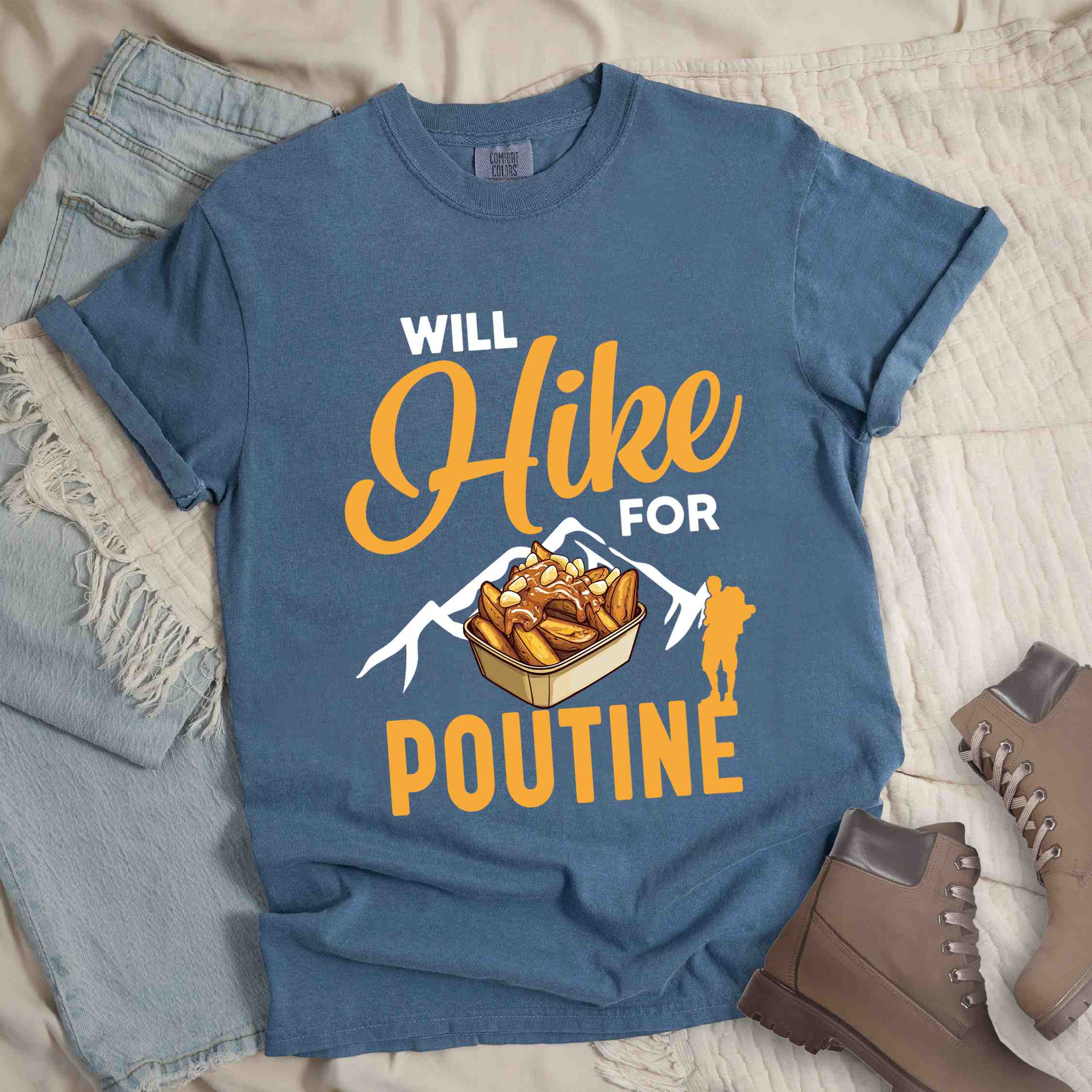 blue jean "Will hike for poutine" colored vintage tee with bold typography, mountains, illustrated a serving of poutine and backpackers looking for comfort food.