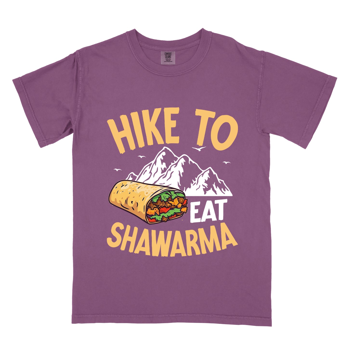 Berry (Dark Violet) t-shirt with golden yellow and white text reading "HIKE TO EAT SHAWARMA". "HIKE TO" appears in golden yellow letters at the top, "EAT" in white in the middle, and "SHAWARMA" in golden yellow at the bottom. Features a detailed illustration of a shawarma wrap with visible meat and vegetables, white mountain silhouettes with small bird silhouettes in the background. 