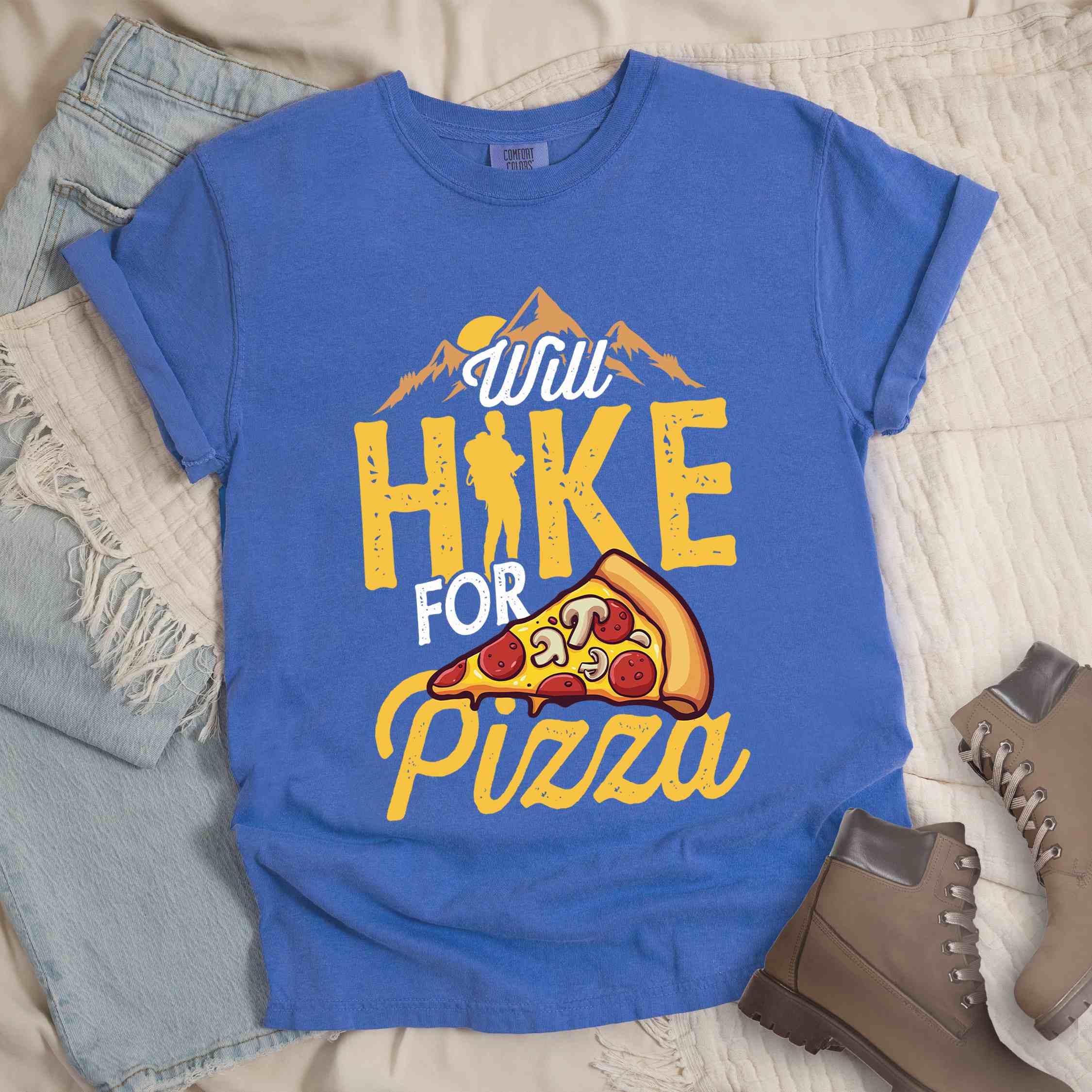 Flo blue colored vintage tee featuring Hiking design of mountains with a sunrise behind and a slice of pizza in front of the phrase 'Will Hike for Pizza'.