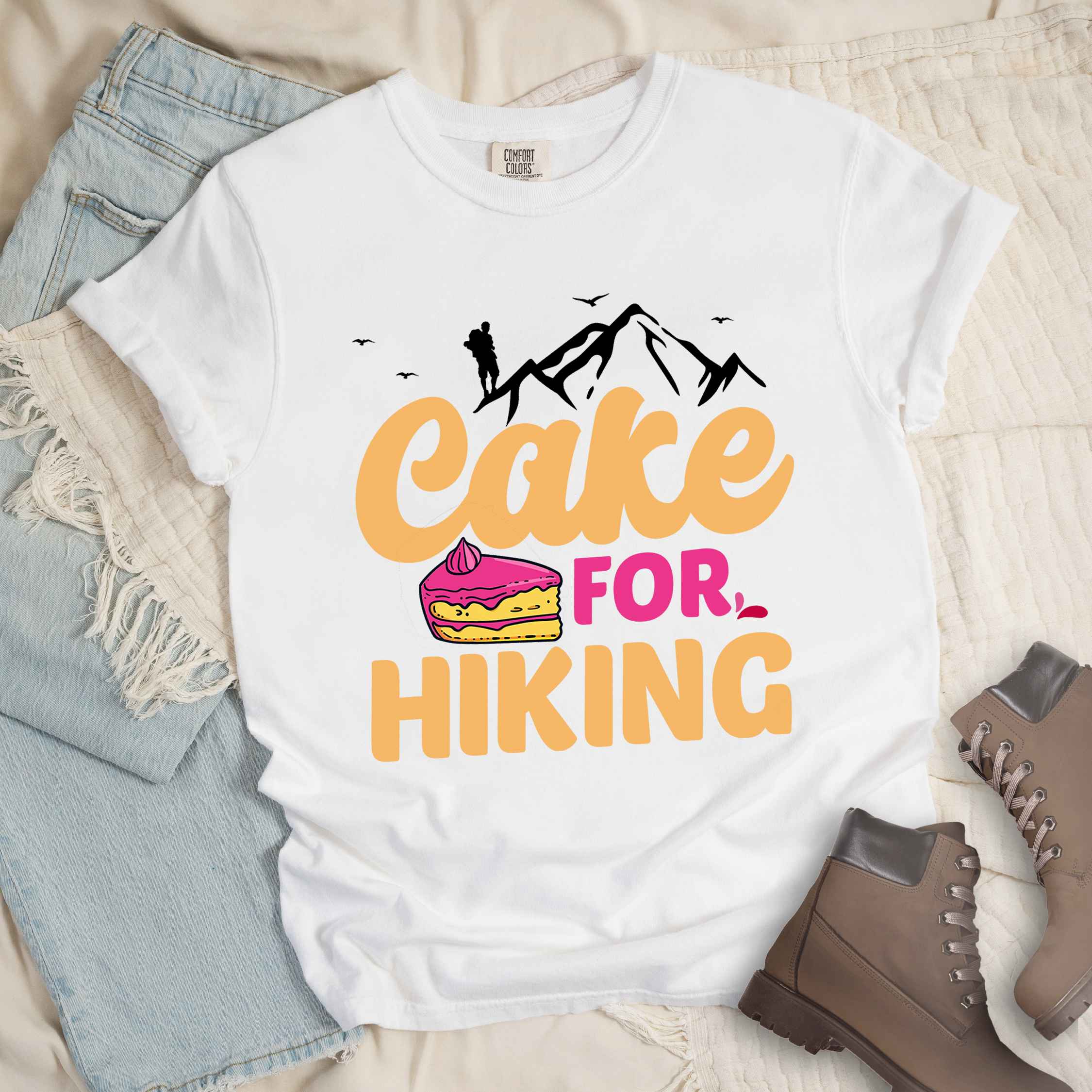 White "Cake for Hiking" colored vintage tee with bold typography, mountains, illustrated a slice of cake, and backpackers with a sweet tooth.