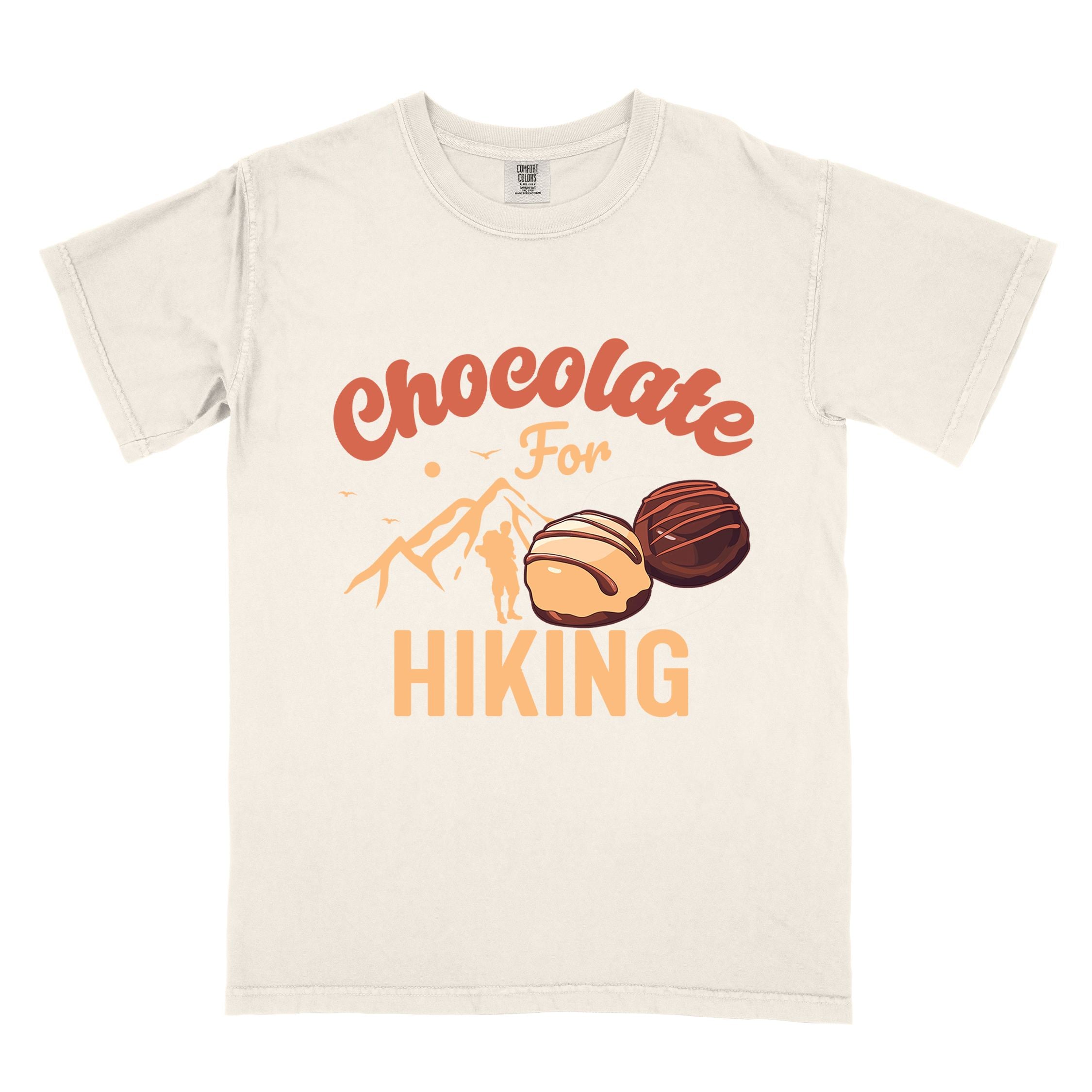 ivory "Chocolate for Hiking" colored vintage tee with bold typography, mountains, illustrated chocolate candies, and backpackers with a sweet tooth.