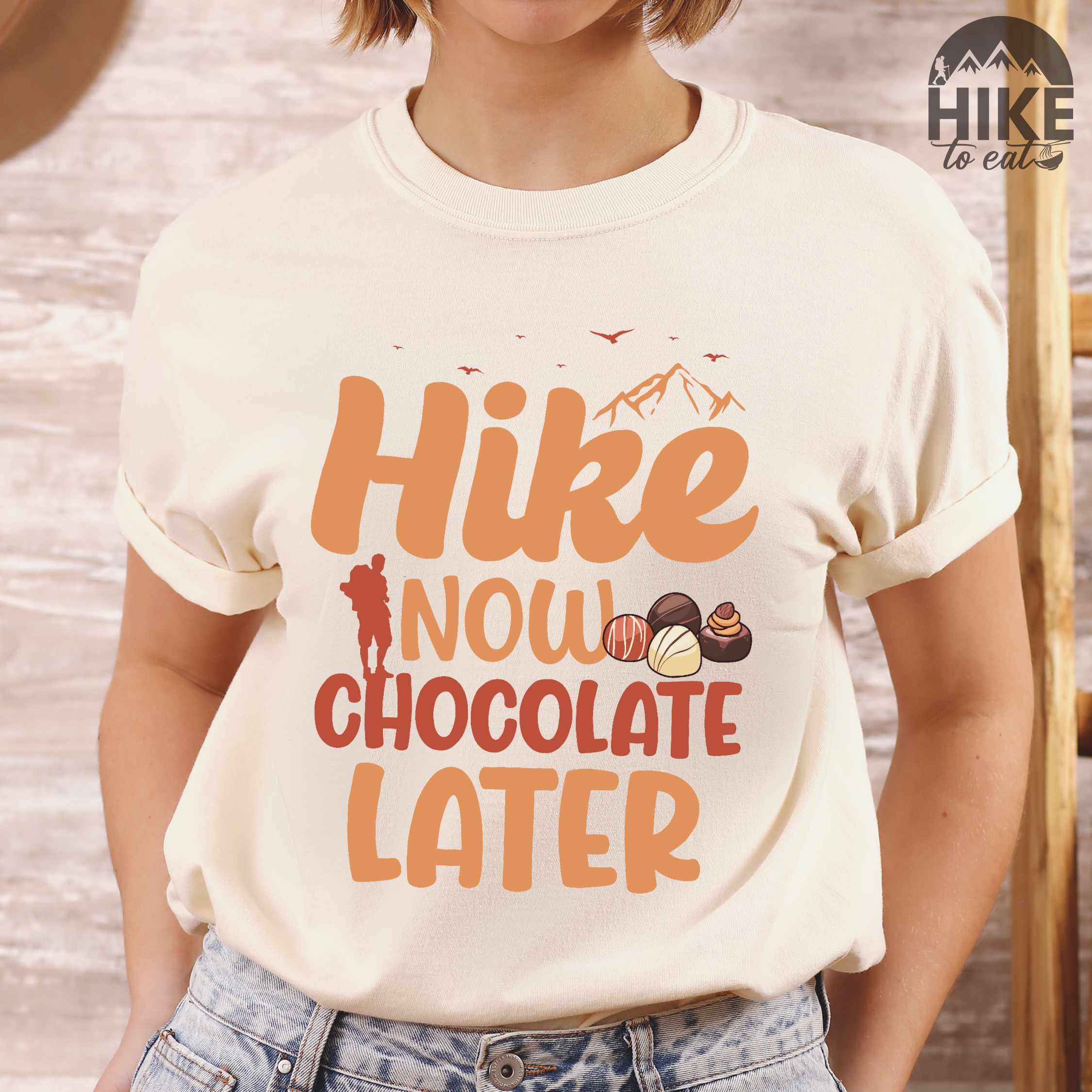 Woman wearing ivory "Hike now chocolate later" colored vintage tee with bold typography, mountains, illustrated a serving of Tiramisu, and perfect for chocolate lovers.