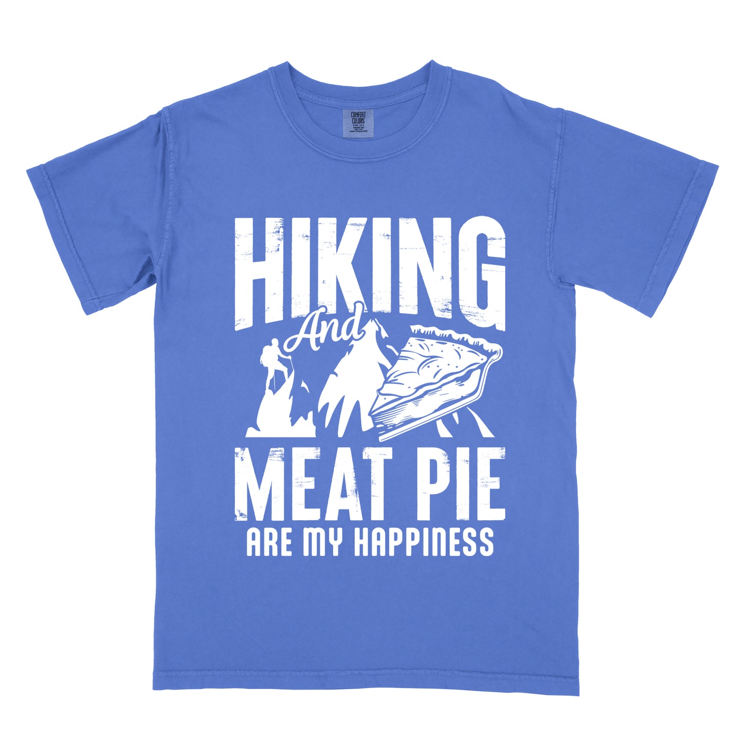 A Flo Blue (Bright Blue) t-shirt featuring white distressed text reading "HIKING And MEAT PIE ARE MY HAPPINESS." Between the words "HIKING" and "MEAT PIE" is a graphic showing a mountain silhouette with a tiny hiker climbing it, alongside an illustration of a slice of meat pie. The design uses only white graphics and text on the Flo Blue (Bright Blue) shirt background in a rugged, vintage style.