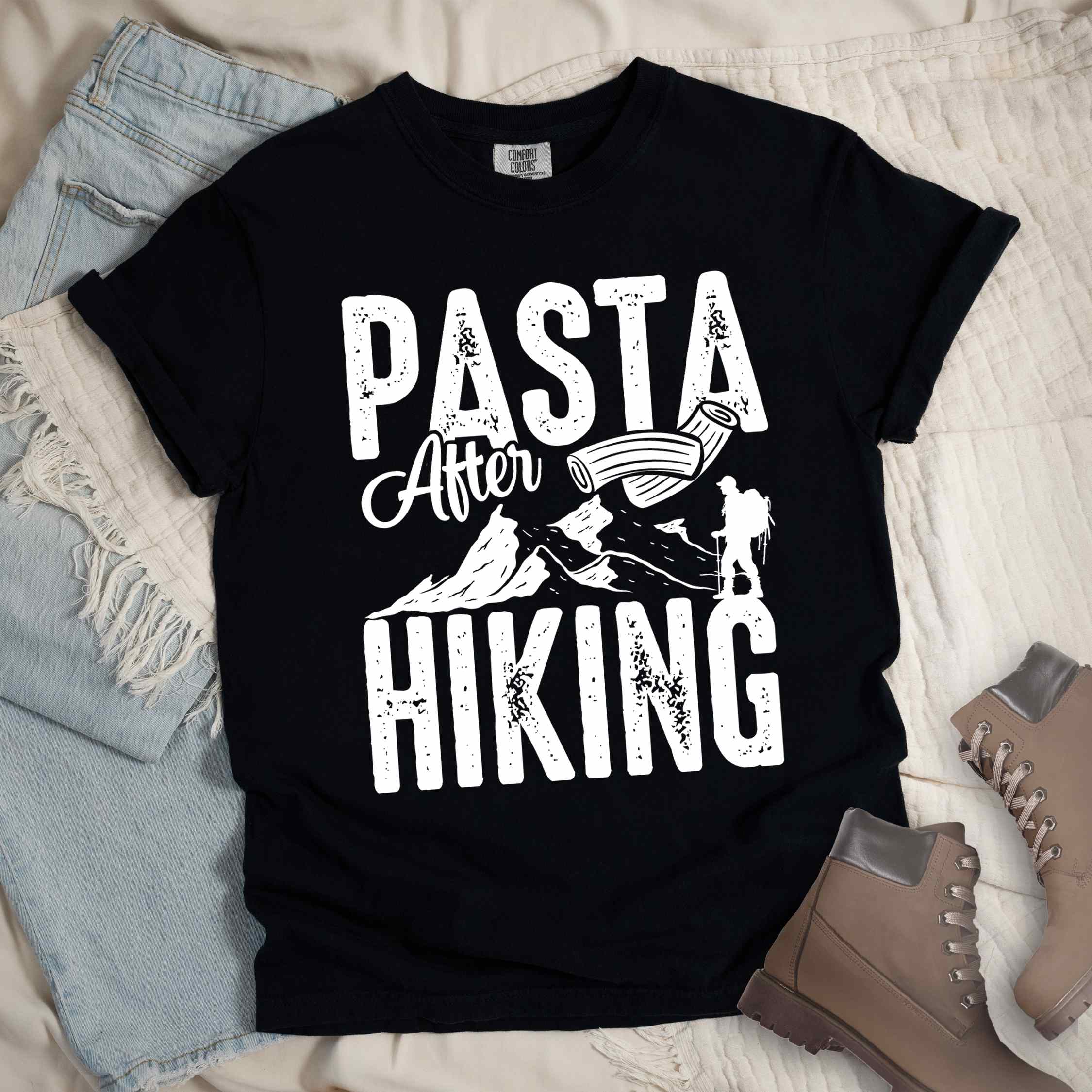 Black "Pasta after hiking" colored vintage tee with bold typography, birds, mountains, illustrated pieces of pasta, and backpackers for pasta lovers.