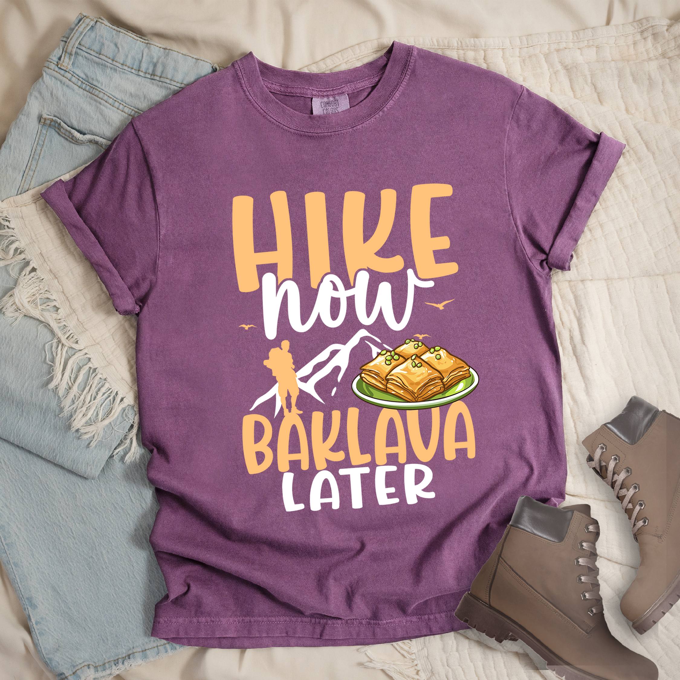 Dark pink shirt with Hiking Design featuring the phrase “Will Hike for Baklava” in bold lettering and a colorful illustration of golden baklava on a plate.
