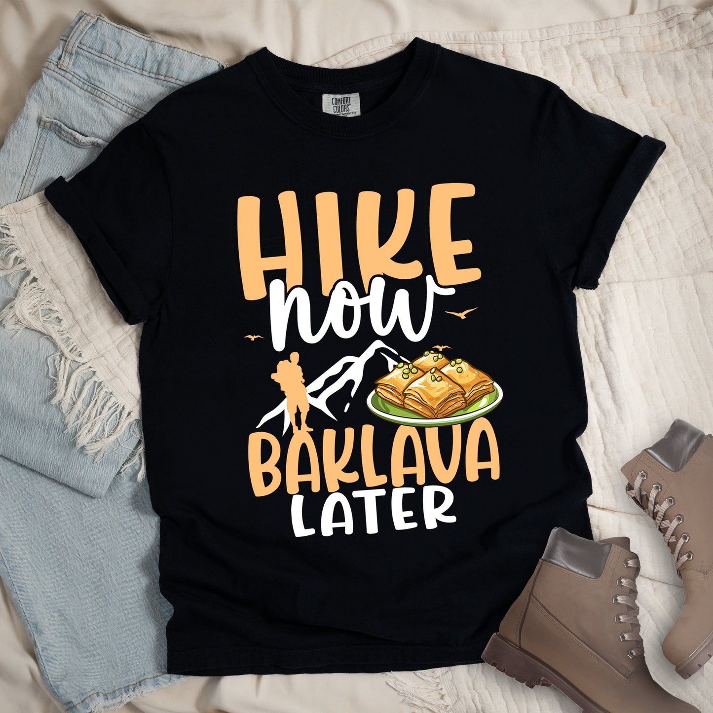 Black shirt with Hiking Design featuring the phrase “Will Hike for Baklava” in bold lettering and a colorful illustration of golden baklava on a plate.