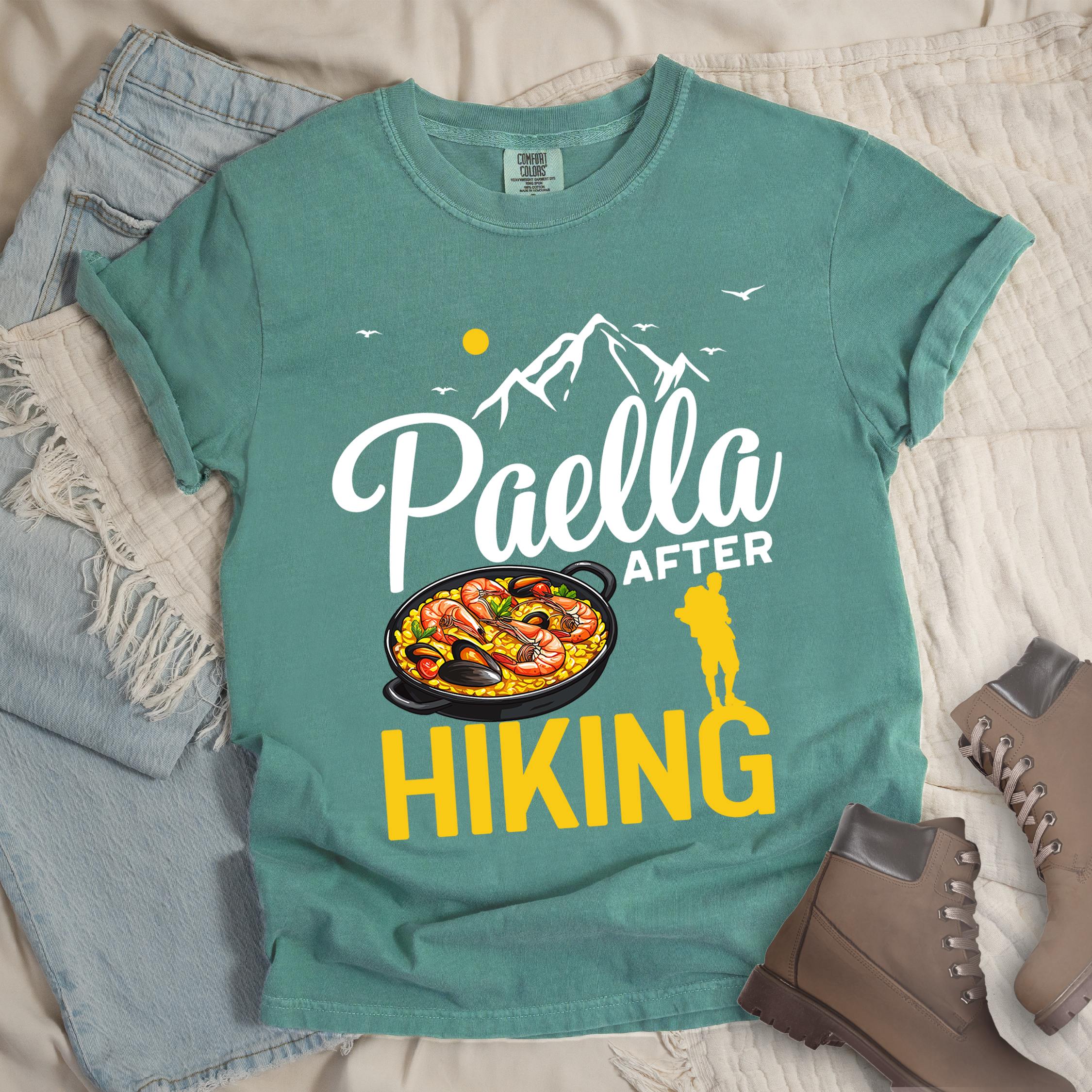Green shirt with Hiking Design featuring the phrase “Paella After Hiking” and an illustration of a paella pan with seafood and rice.