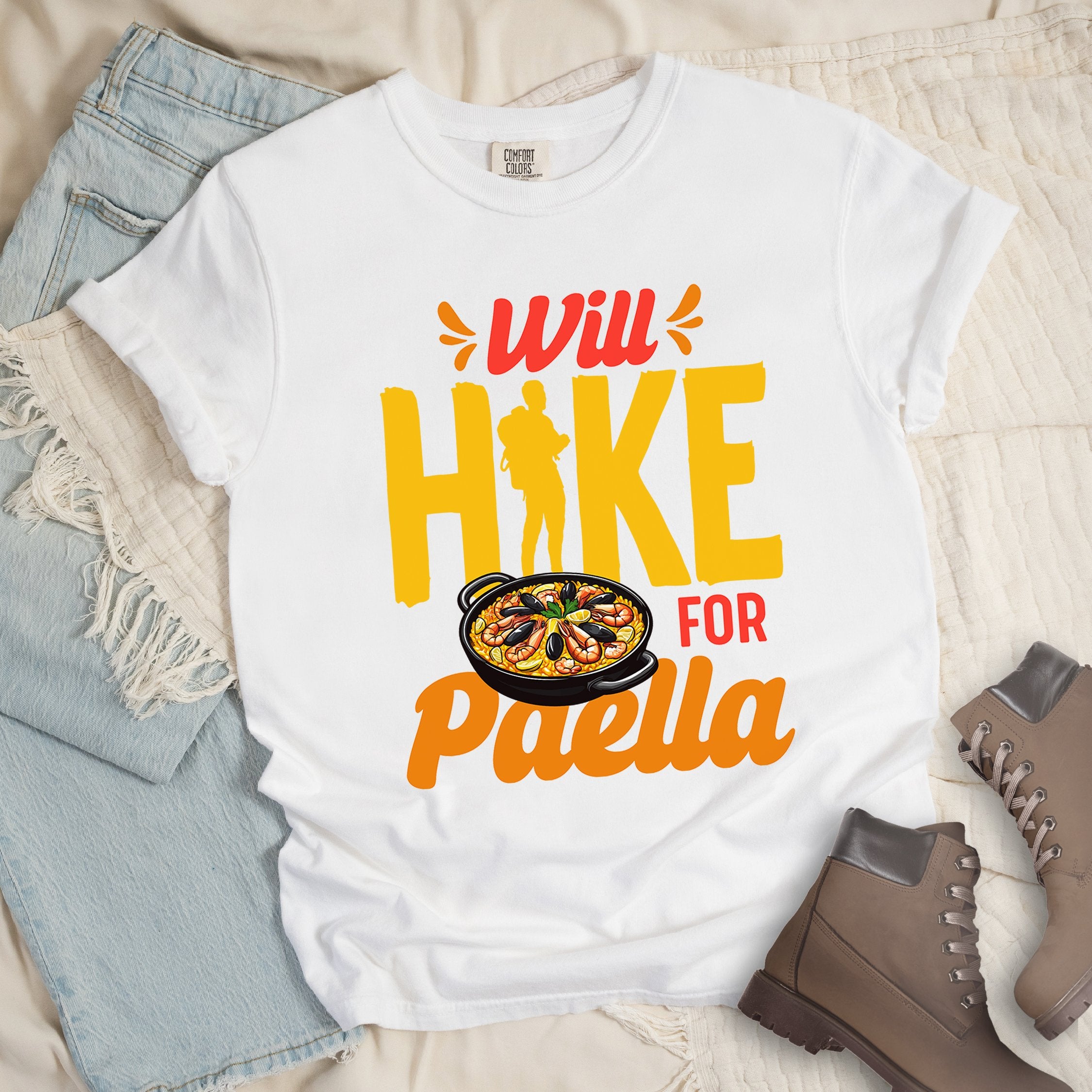 White shirt with Hiking Design featuring the phrase “Will Hike for Paella” and a detailed illustration of a pan filled with paella.