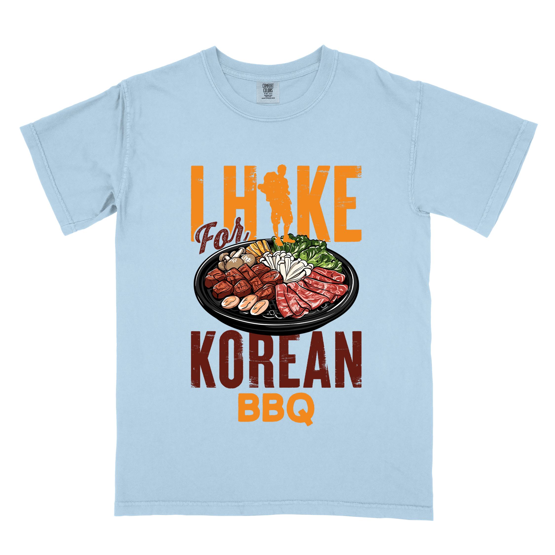 Chambray "I hike for korean bbq" colored vintage tee with bold typography, illustrated grilling platter korean bbq, mountains, birds, and backpacker for kbbq lovers.