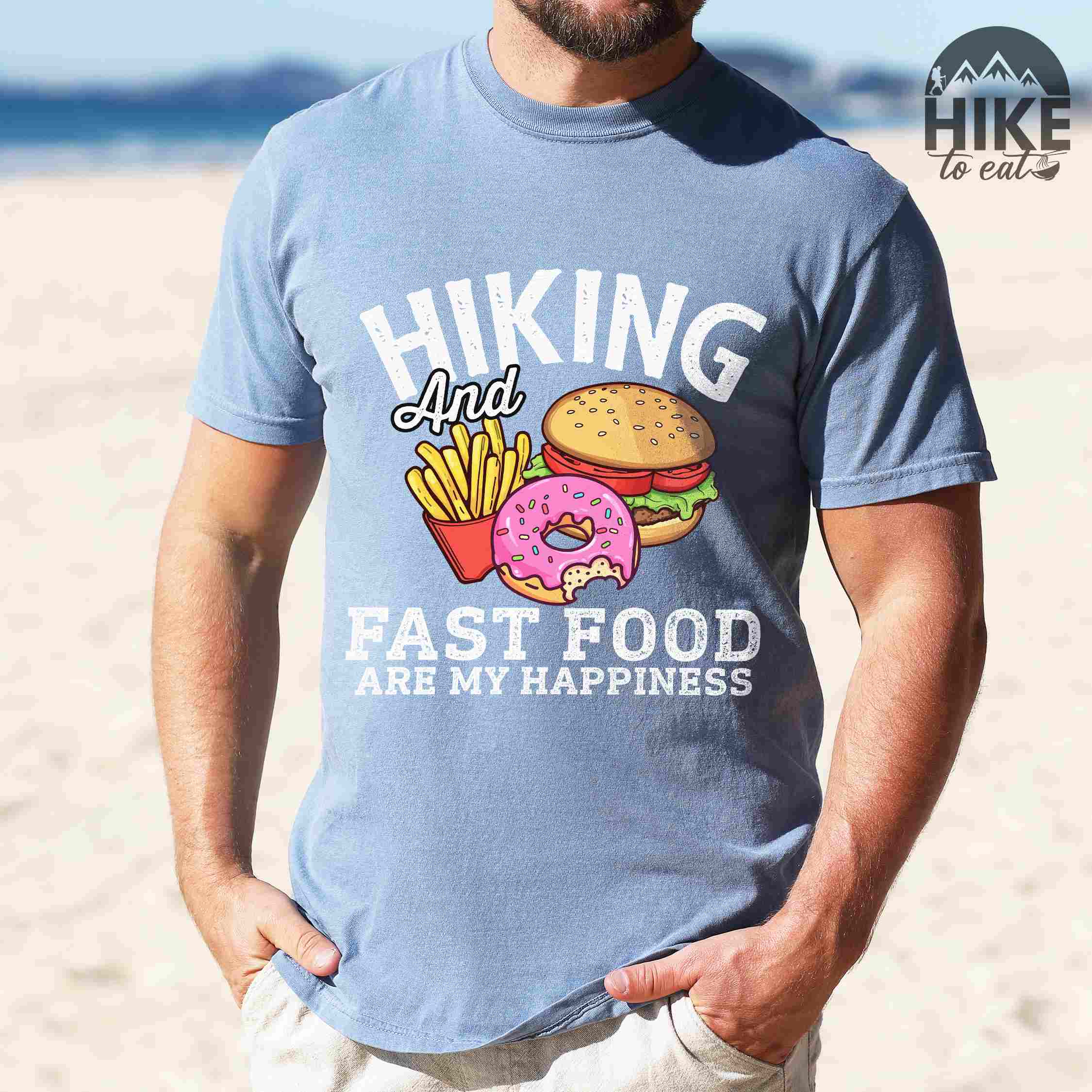 Man wearing blue jean "Hiking and Fast Food are my Happiness" colored vintage tee with bold typography, and illustrated fast food meal for the hikers who wants a rewarding meal.