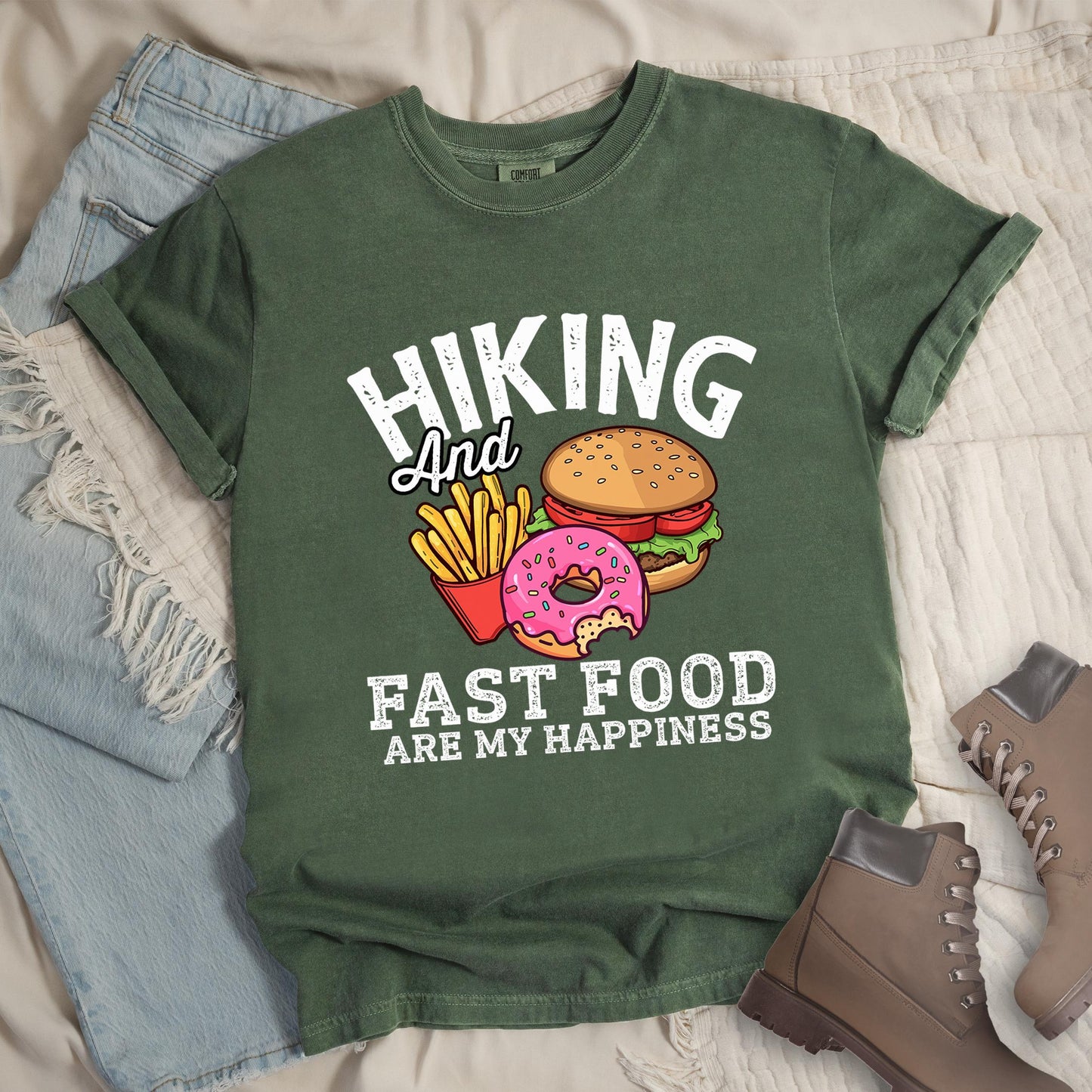Dark green shirt showing a hiking design with 'Hiking and fast food are my happiness' phrase and an illustration of fast food meal in front. 